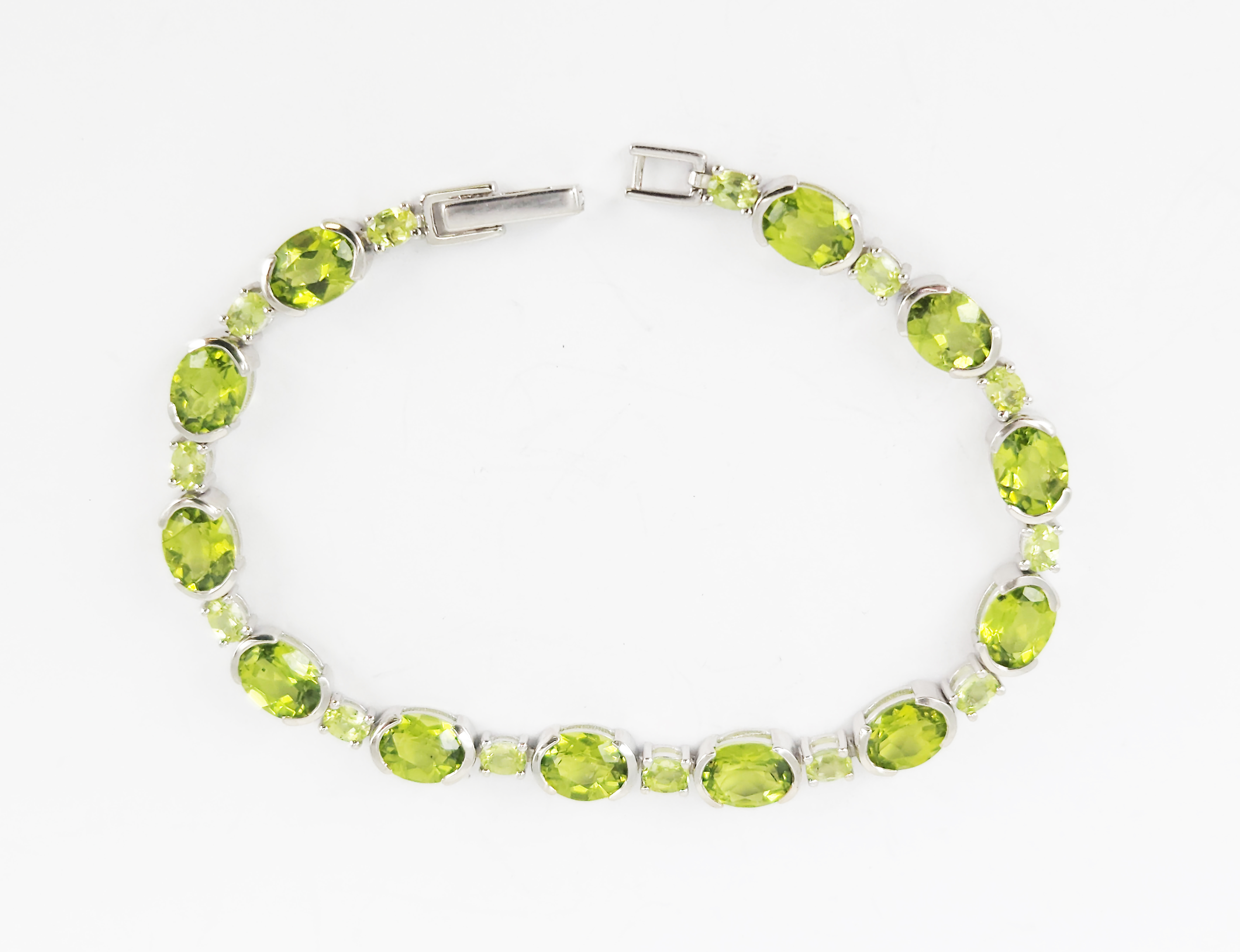 378 · A SILVER AND OVAL PERIDOT TENNIS BRACELET