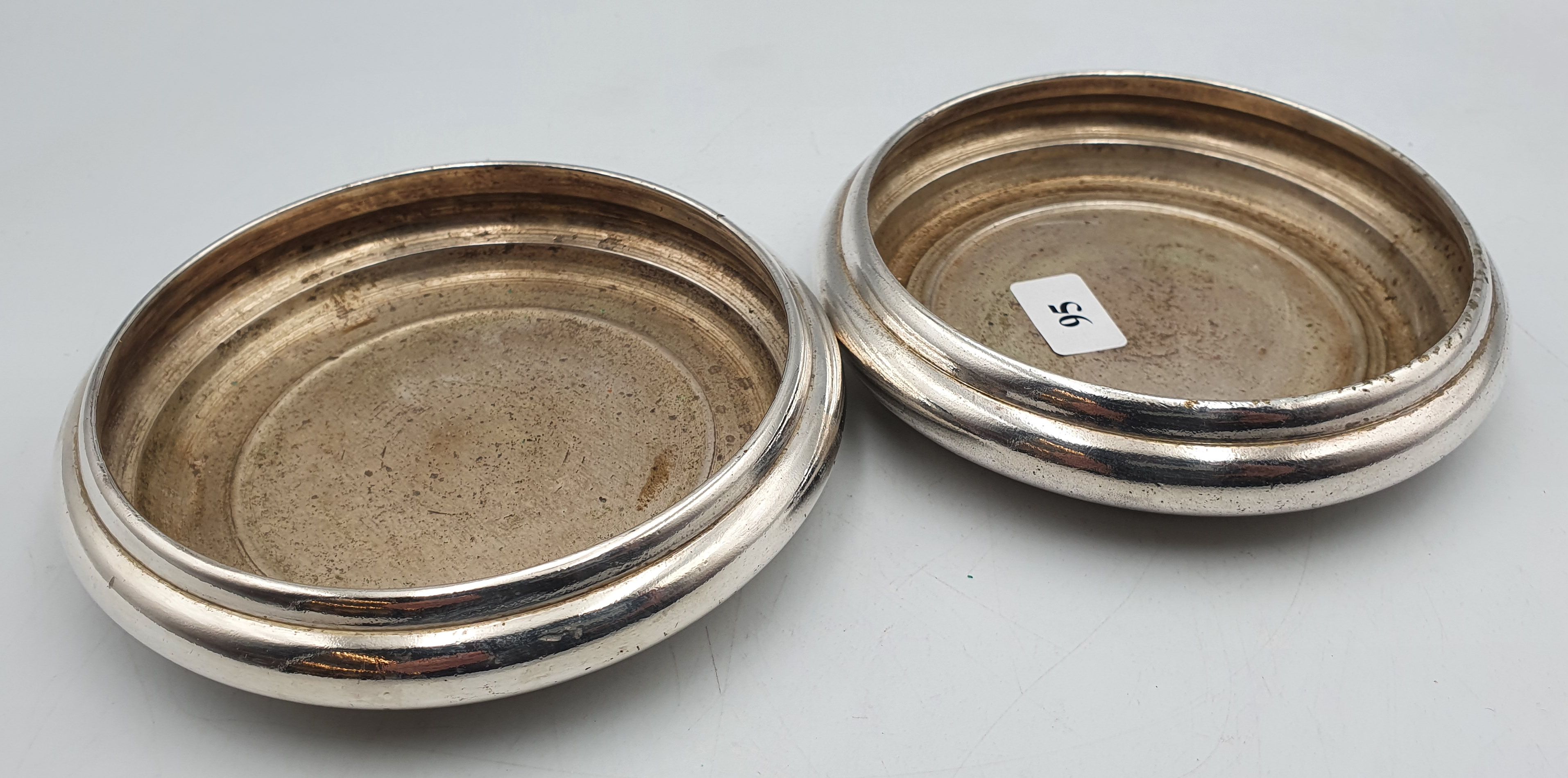 95 · A PAIR OF HEAVY SILVERPLATED WINE BOTTLE COASTERS