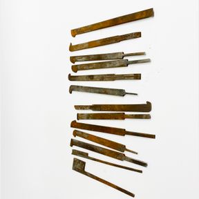 A quantity of various antique chisel irons.