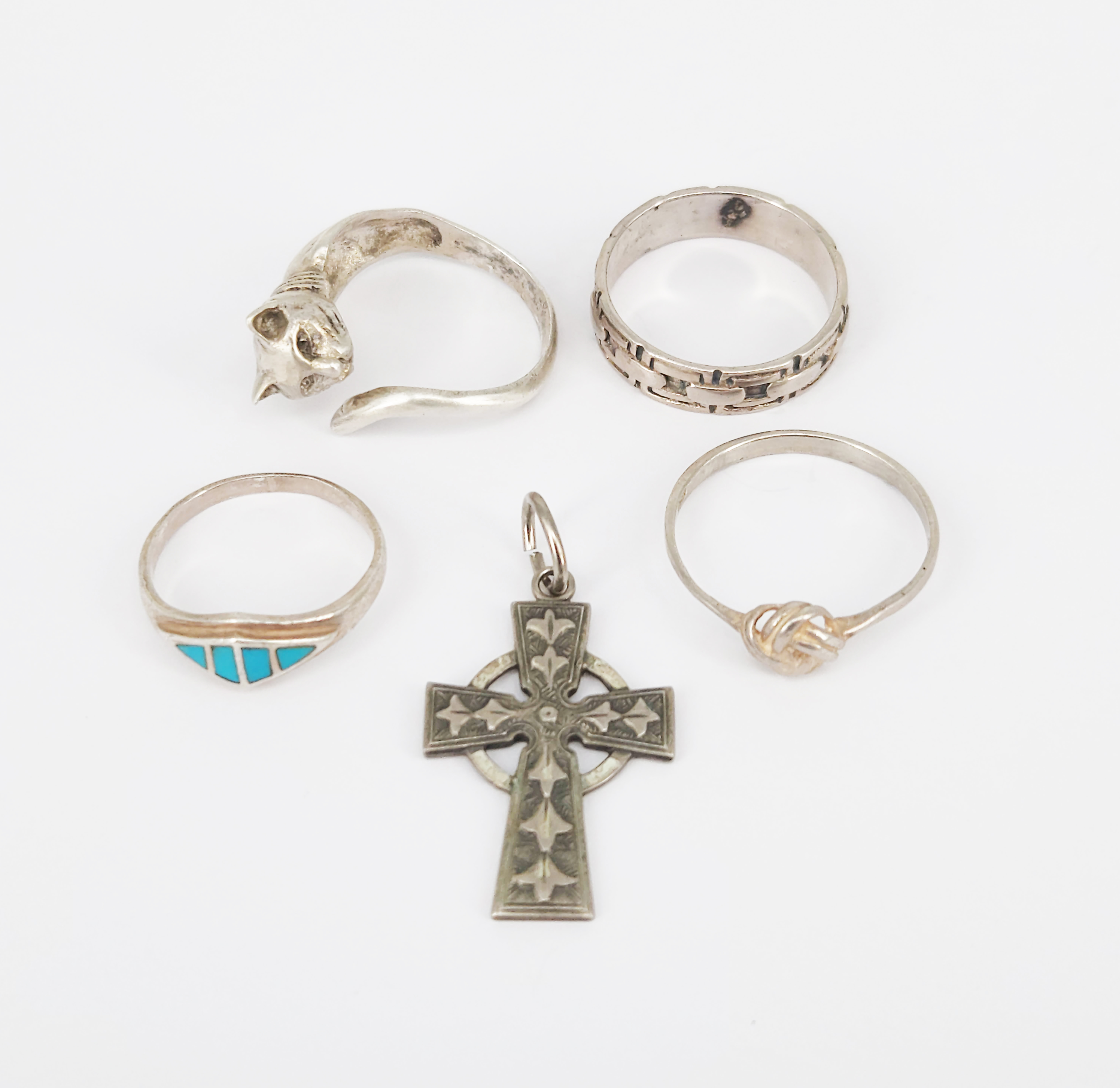 399 · FOUR SILVER RINGS AND A CELTIC SILVER CROSS