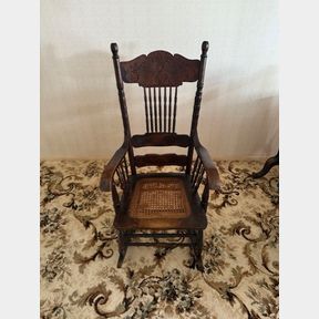 AMERICAN CARVED ROCKING CHAIR WITH ORNATE DETAIL