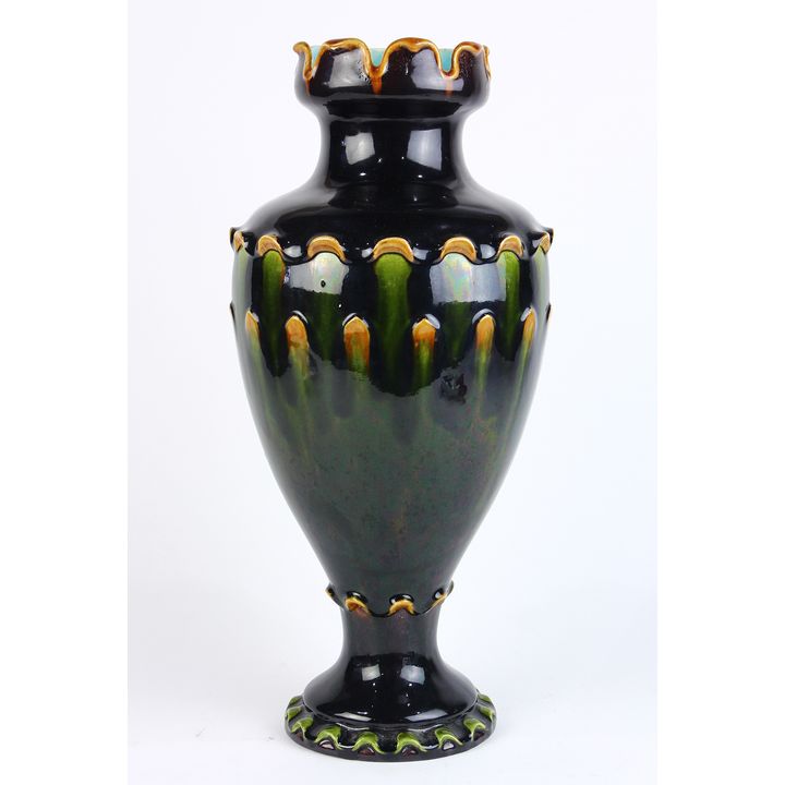 Continental majolica vase, having a flared rim, above an urn form body, exectued in black, green, and goldenrod, and having a light...