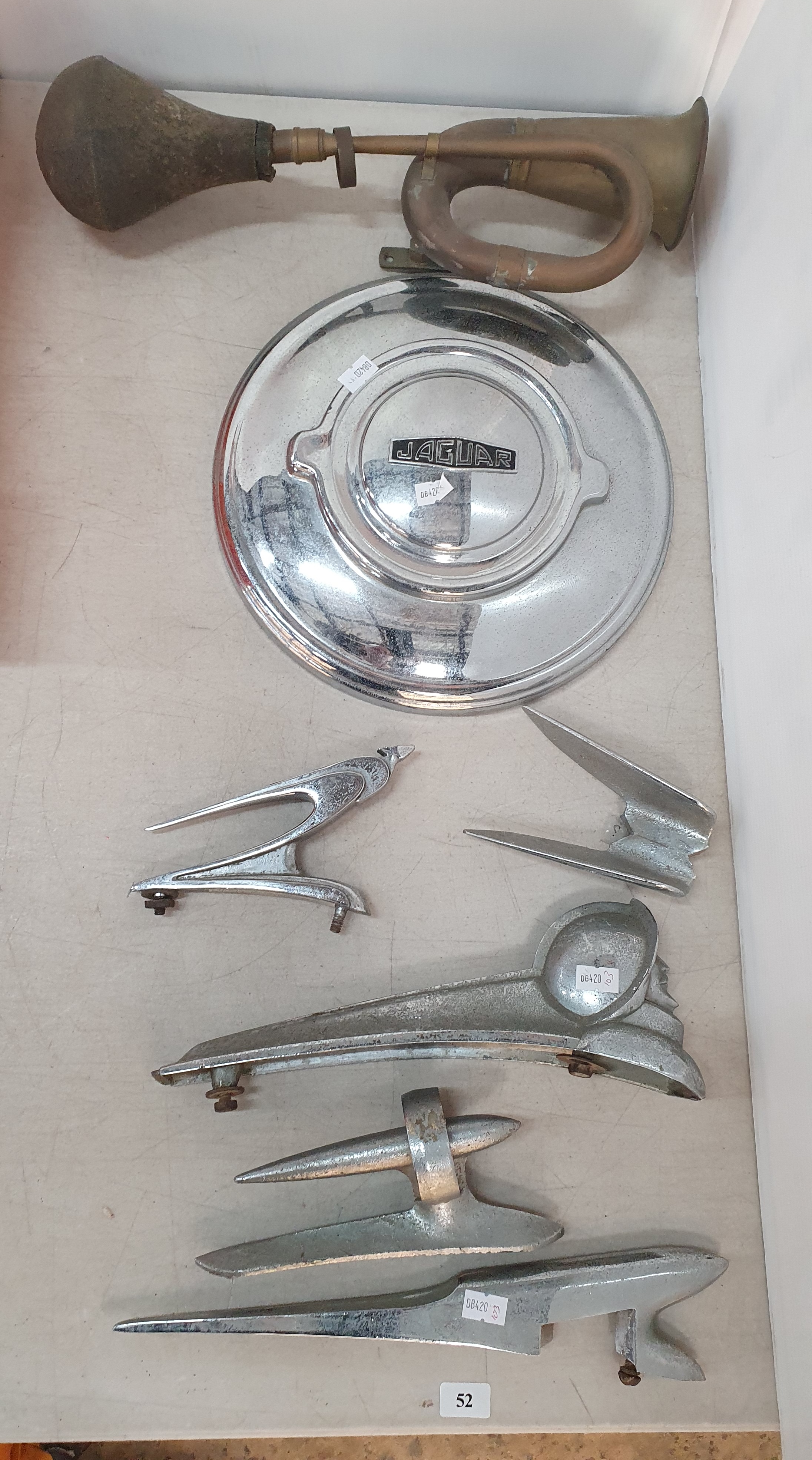 52 · A GROUP OF CAR BONNET MASCOT/ORNAMENTS TOGETHER WITH A JAGUAR HUBCAP AND A HORN