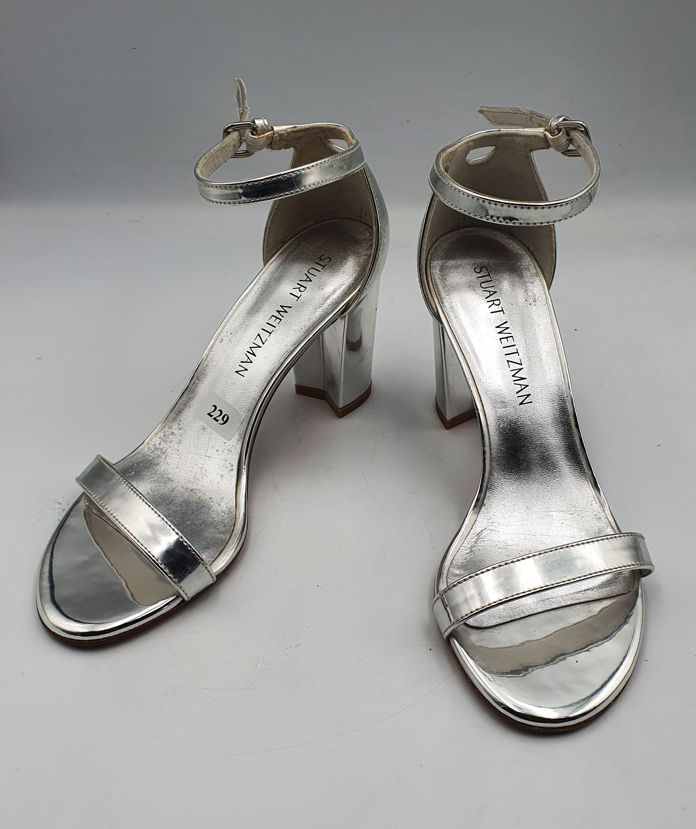 229 · A PAIR OF STUART WEITZMAN SILVER SANDALS