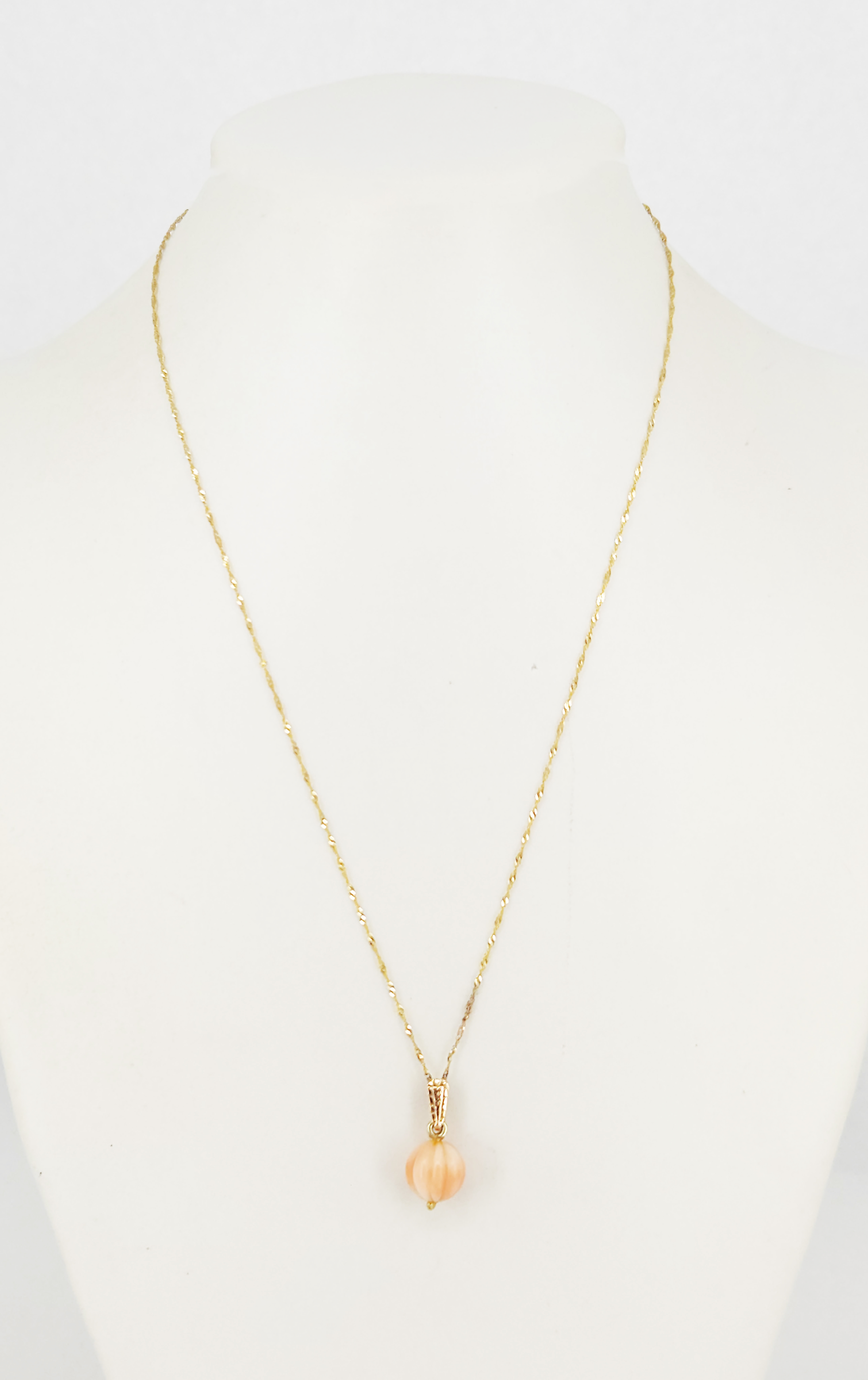 332 · A VINTAGE 18ct YELLOW GOLD AND CARVED CORAL PENDANT ON 9ct YELLOW GOLD CHAIN