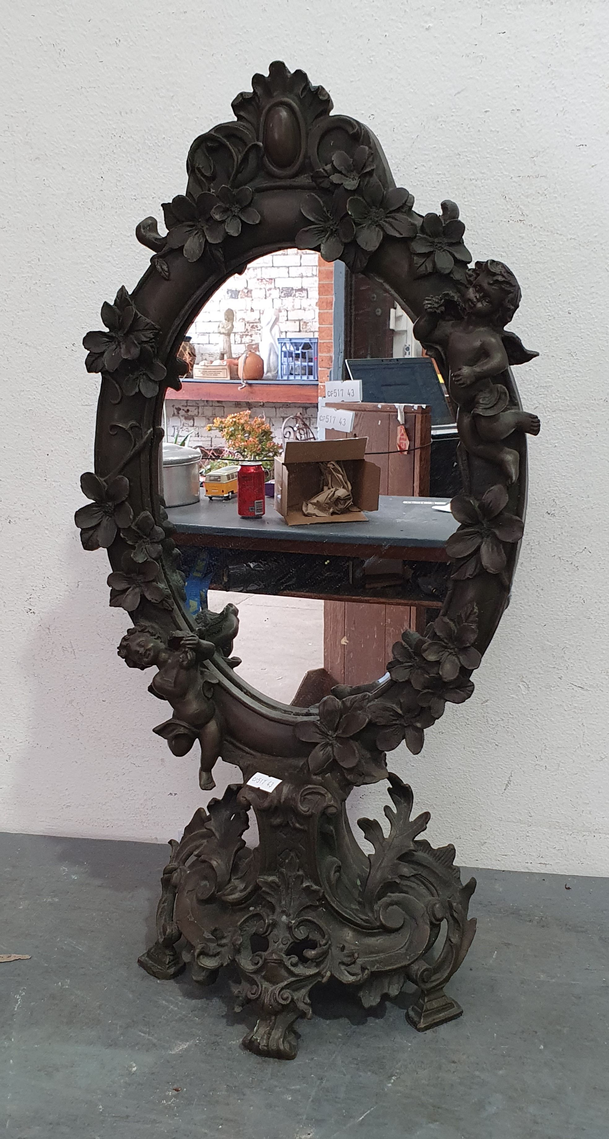 A DECORATIVE CAST METAL MIRROR