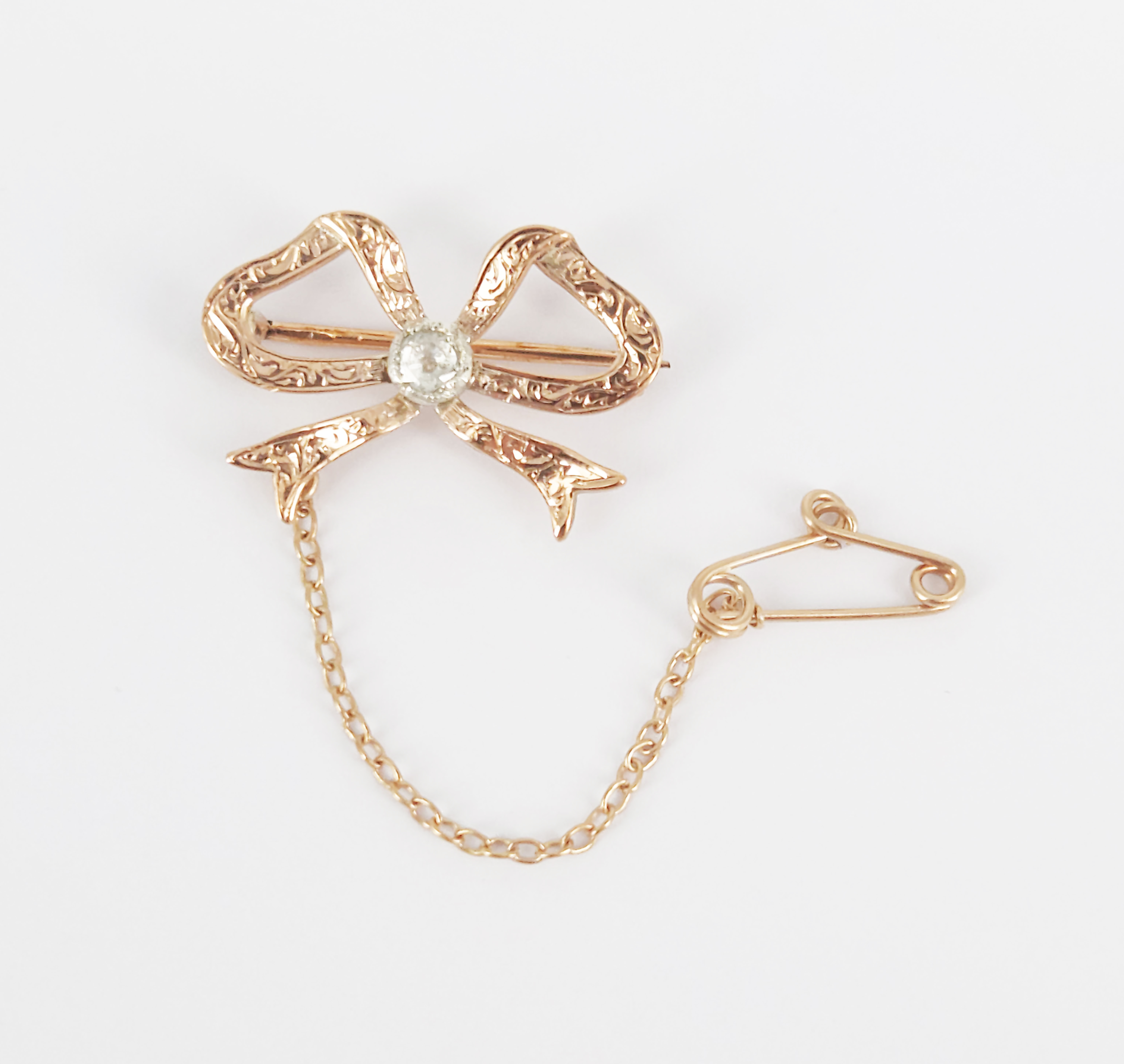 97 · AN ANTIQUE 9ct ROSE GOLD AND ROSE-CUT DIAMOND BOW BROOCH