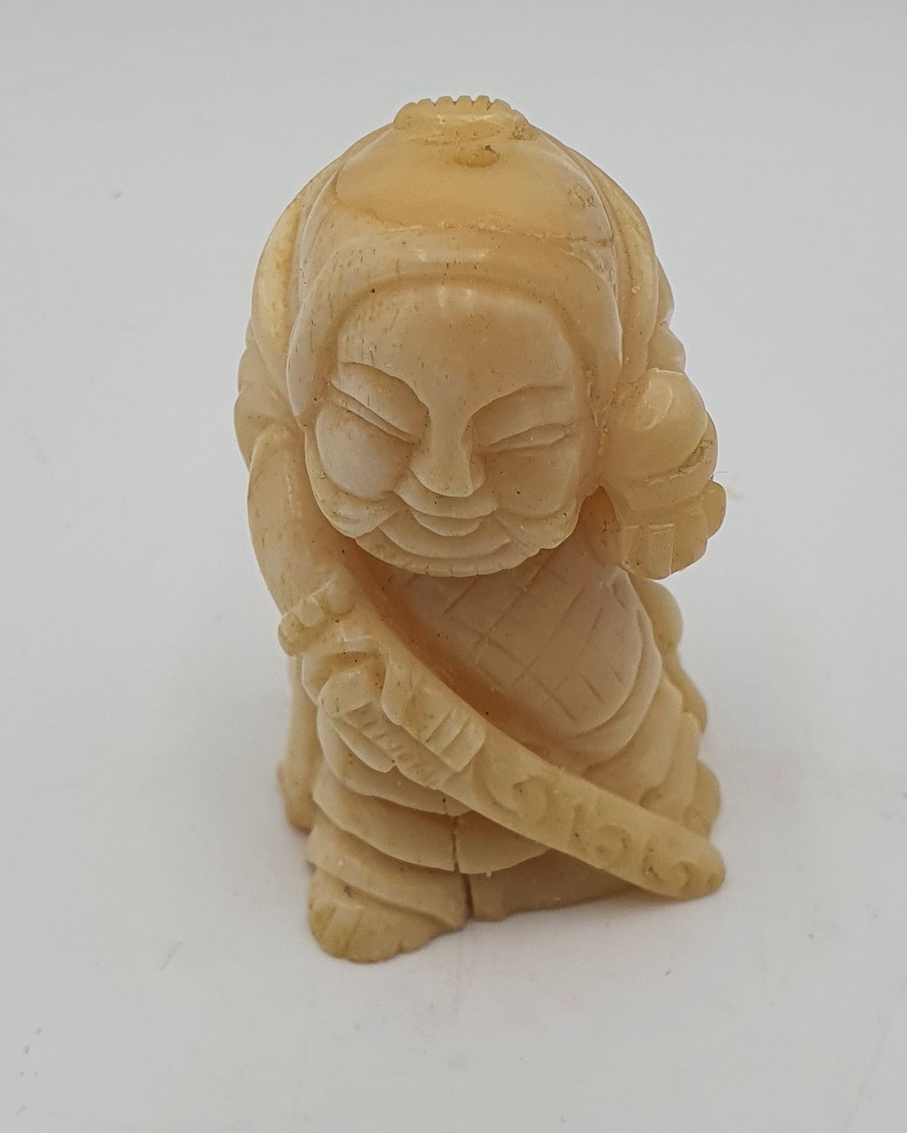 545 · AN ASIAN CARVED FIGURE OF A WARRIOR