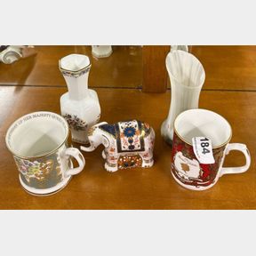 A Royal Crown Derby elephant paper weight with two commemorative items and two others.