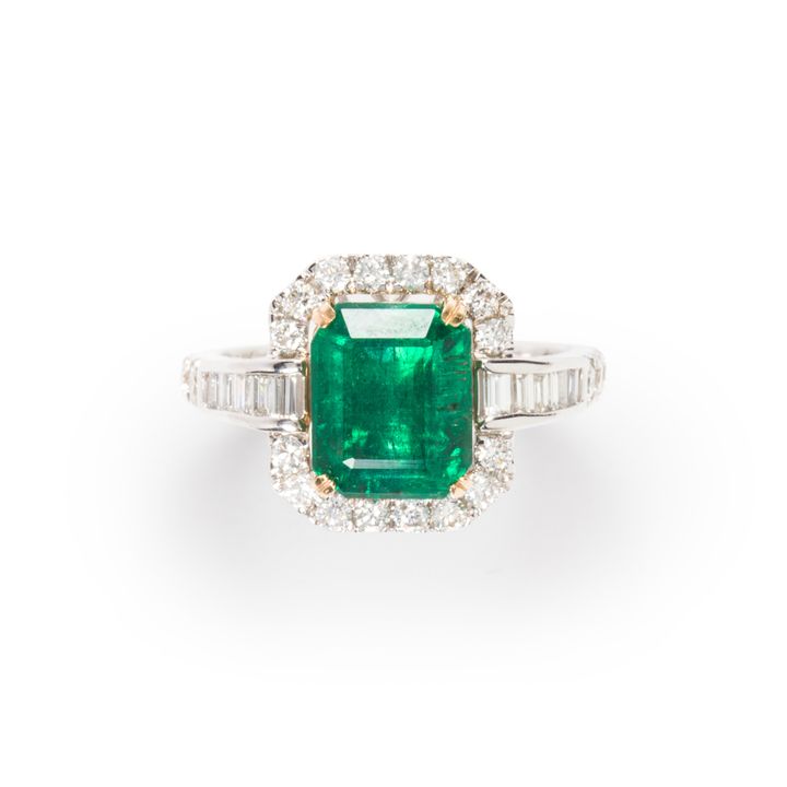 An emerald, diamond and fourteen karat white gold ring
