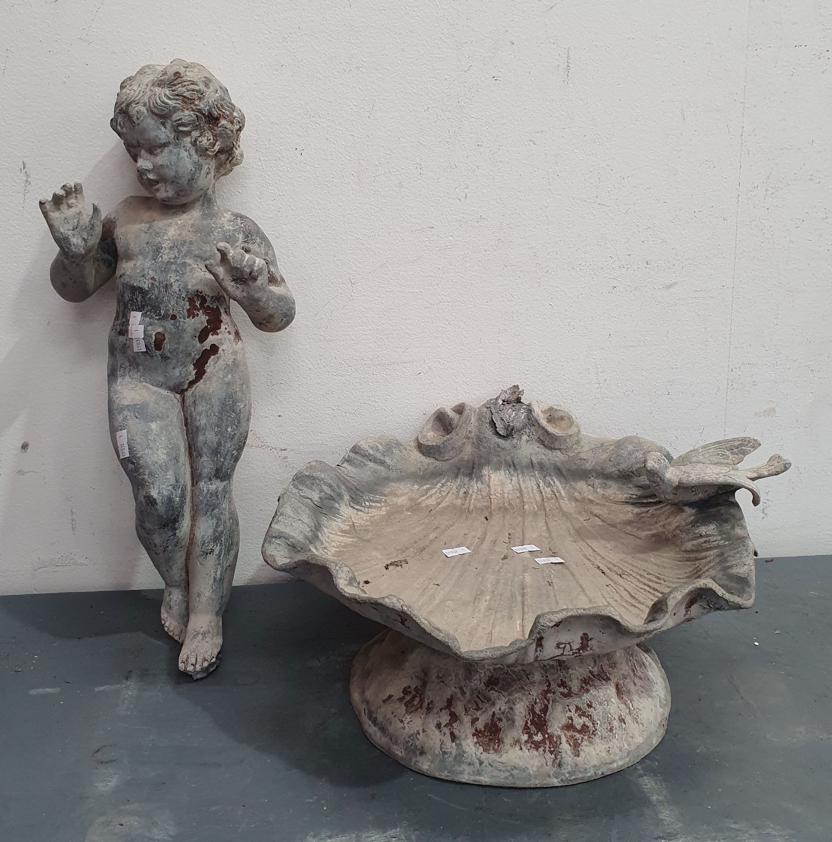 A Metal Bird Bath With Cherrub