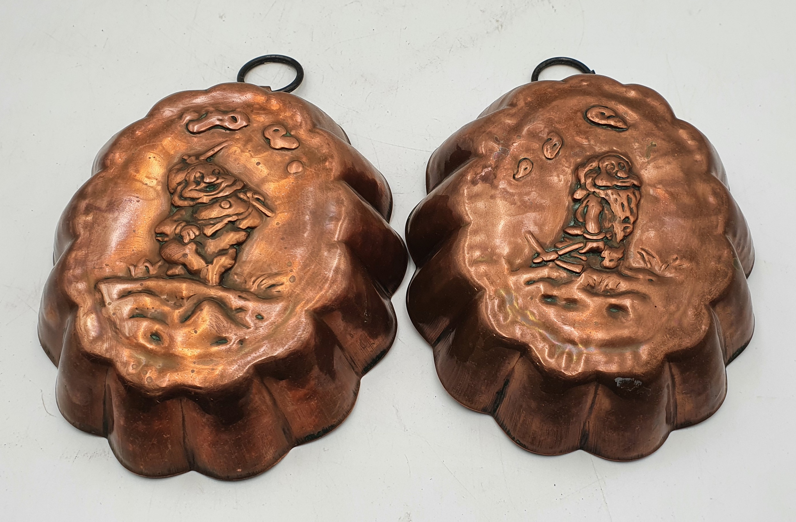 572 · A PAIR OF FRENCH COPPER DISNEY 'SNOW WHITE AND THE SEVEN DWARVES' JELLY MOULDS