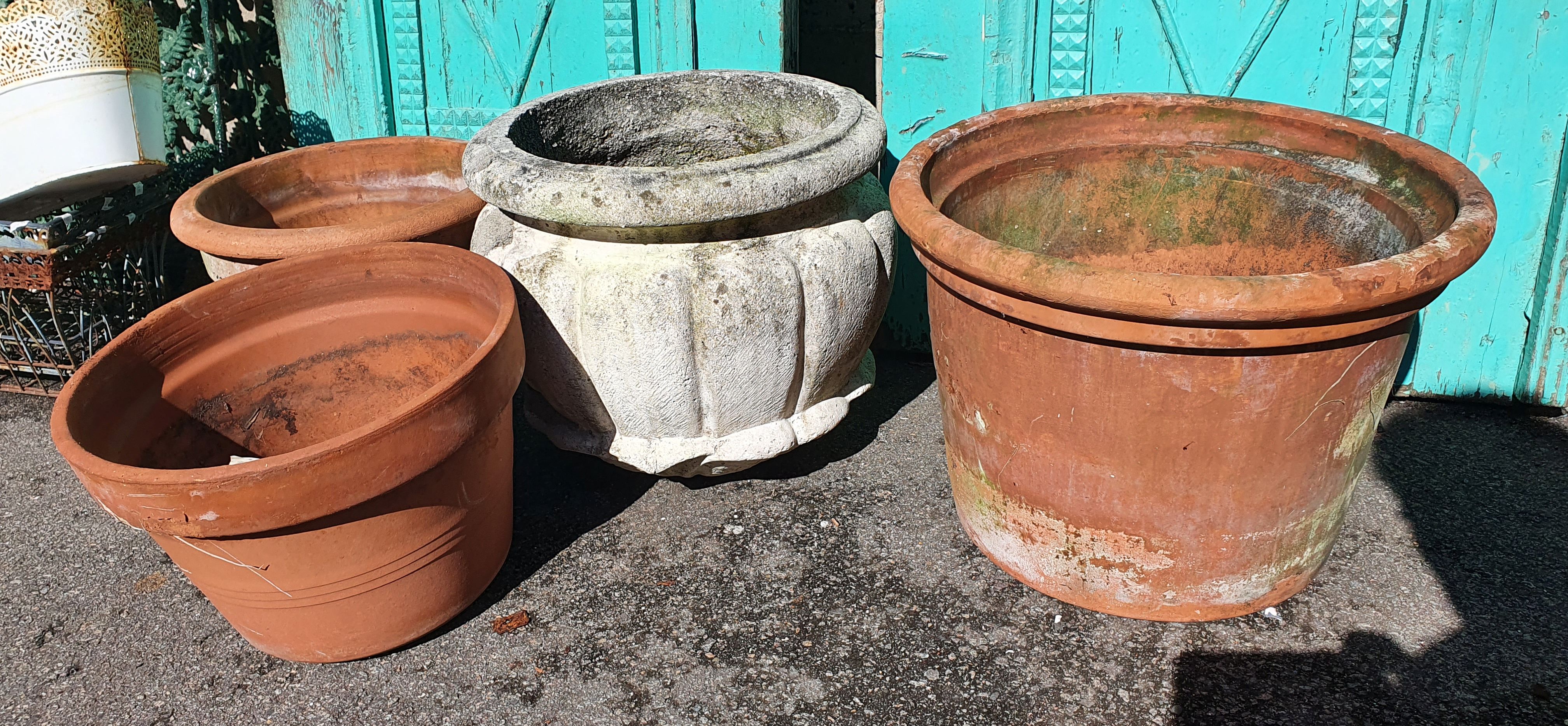 A Stone Pot With A Trio Of Terracotta Pots
