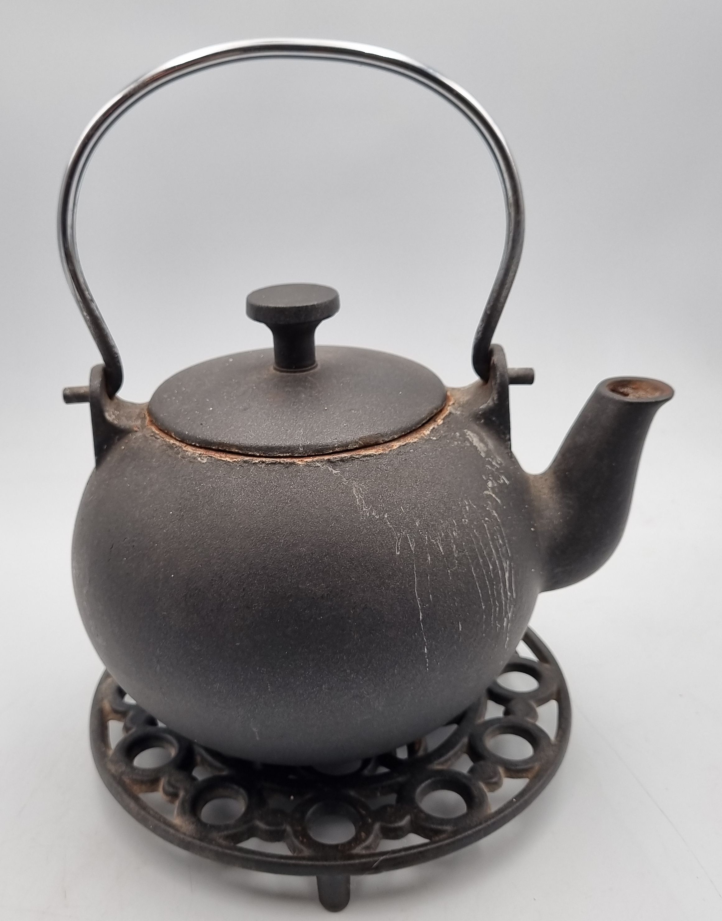 31 · A CAST METAL TEAPOT AND STAND