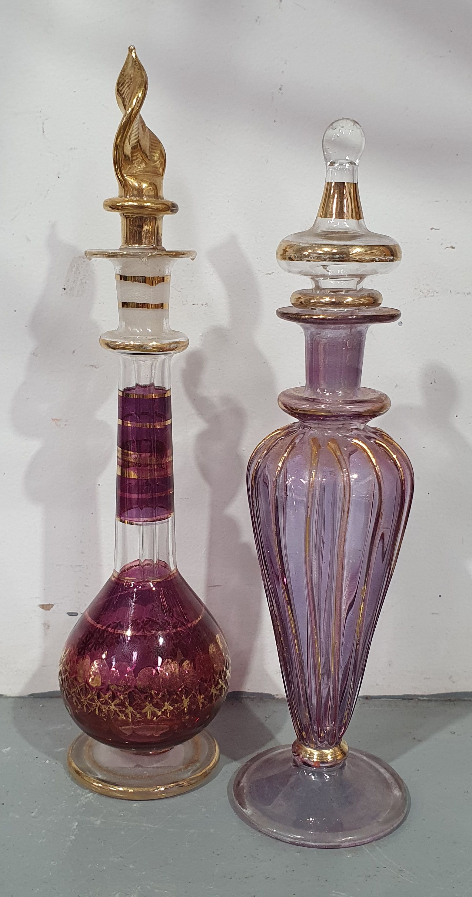 585 · TWO VARIOUS EGYPTIAN GLASS PERFUME BOTTLES WITH STOPPERS