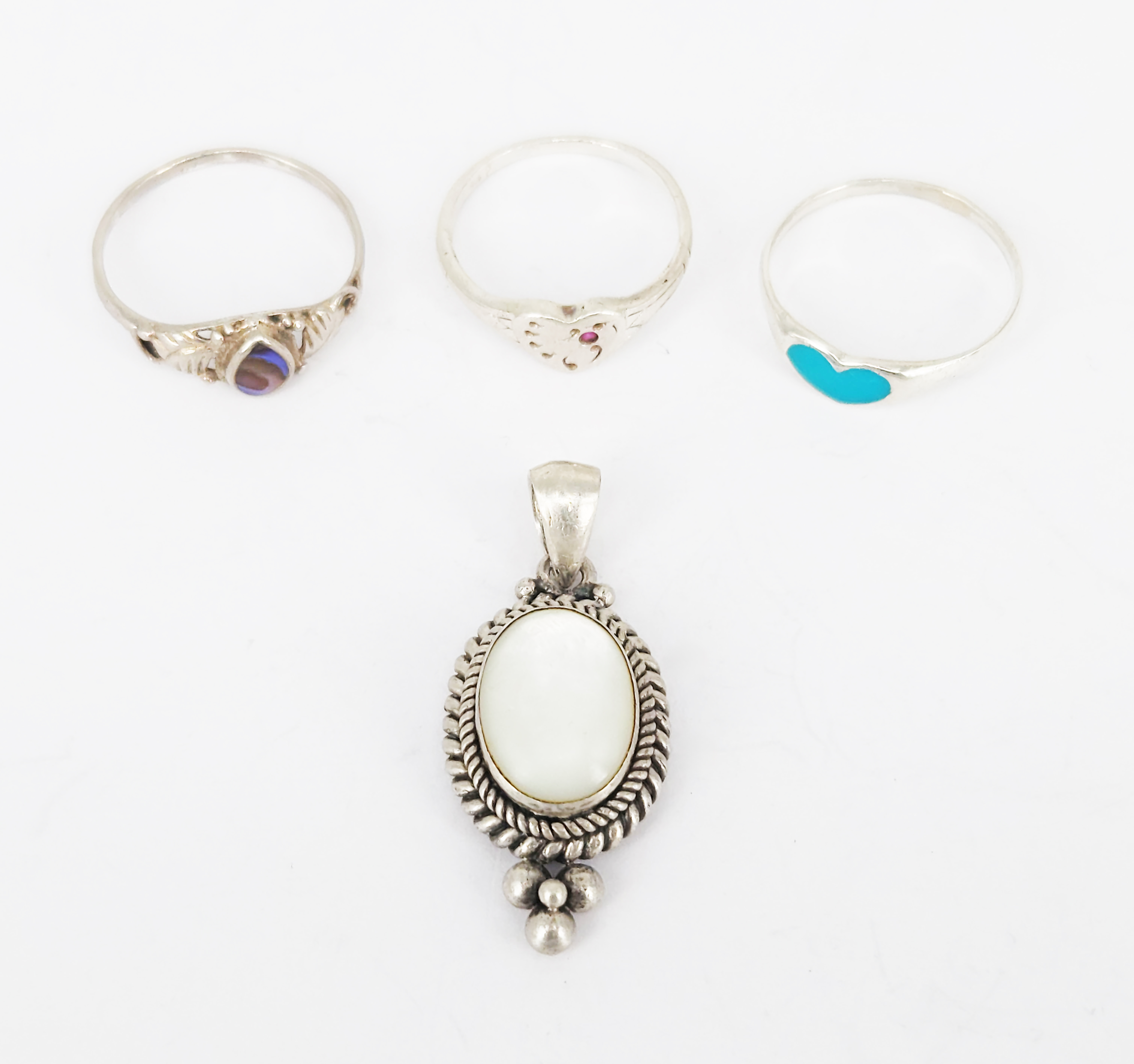 364 · THREE SILVER RINGS AND A SILVER AND MOTHER-OF-PEARL PENDANT