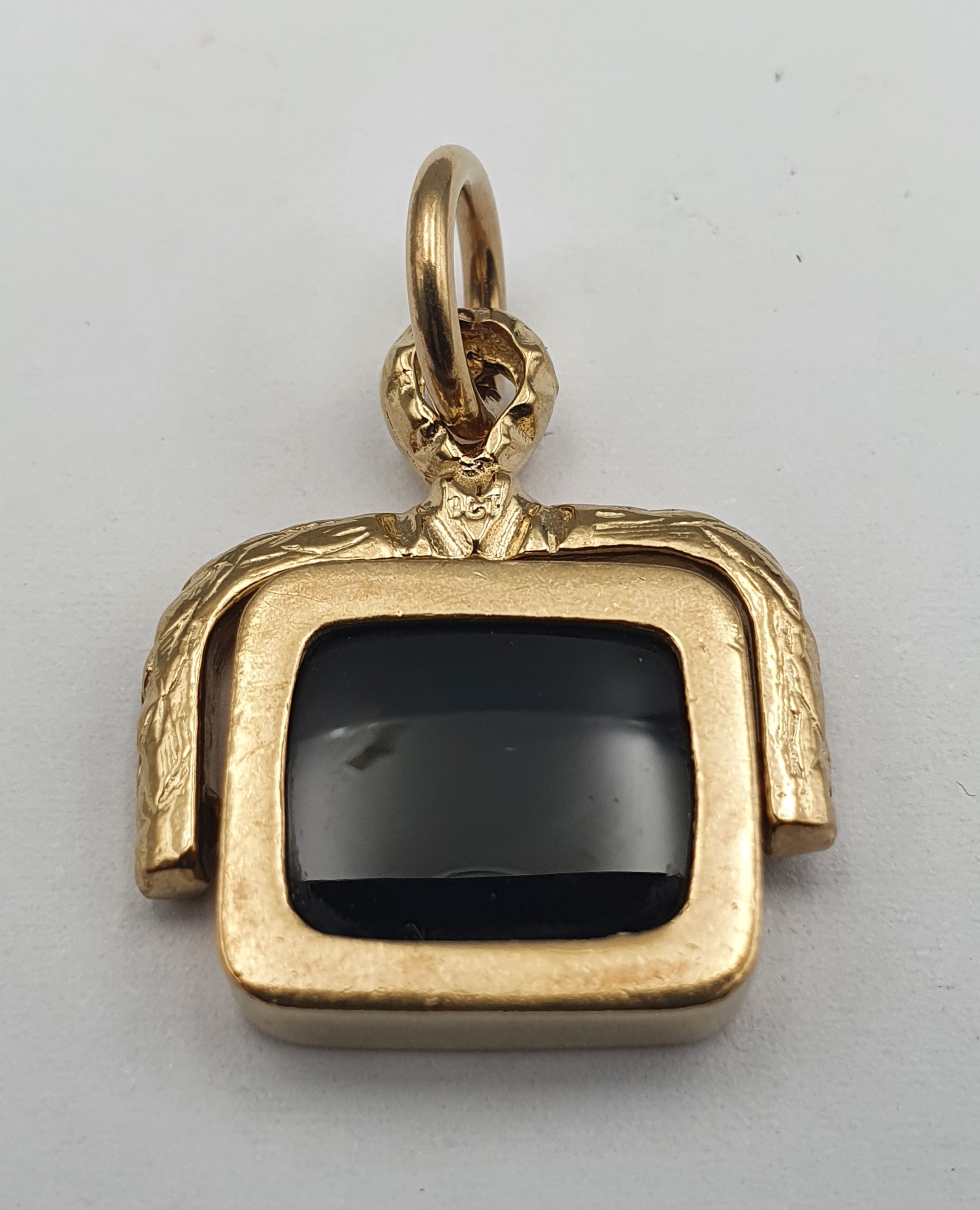 277 · A 9ct AND ONYX SPINNING SILVER FOB PENDANT