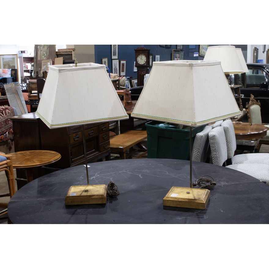 A pair of gilt wood display lamps with square linen shades