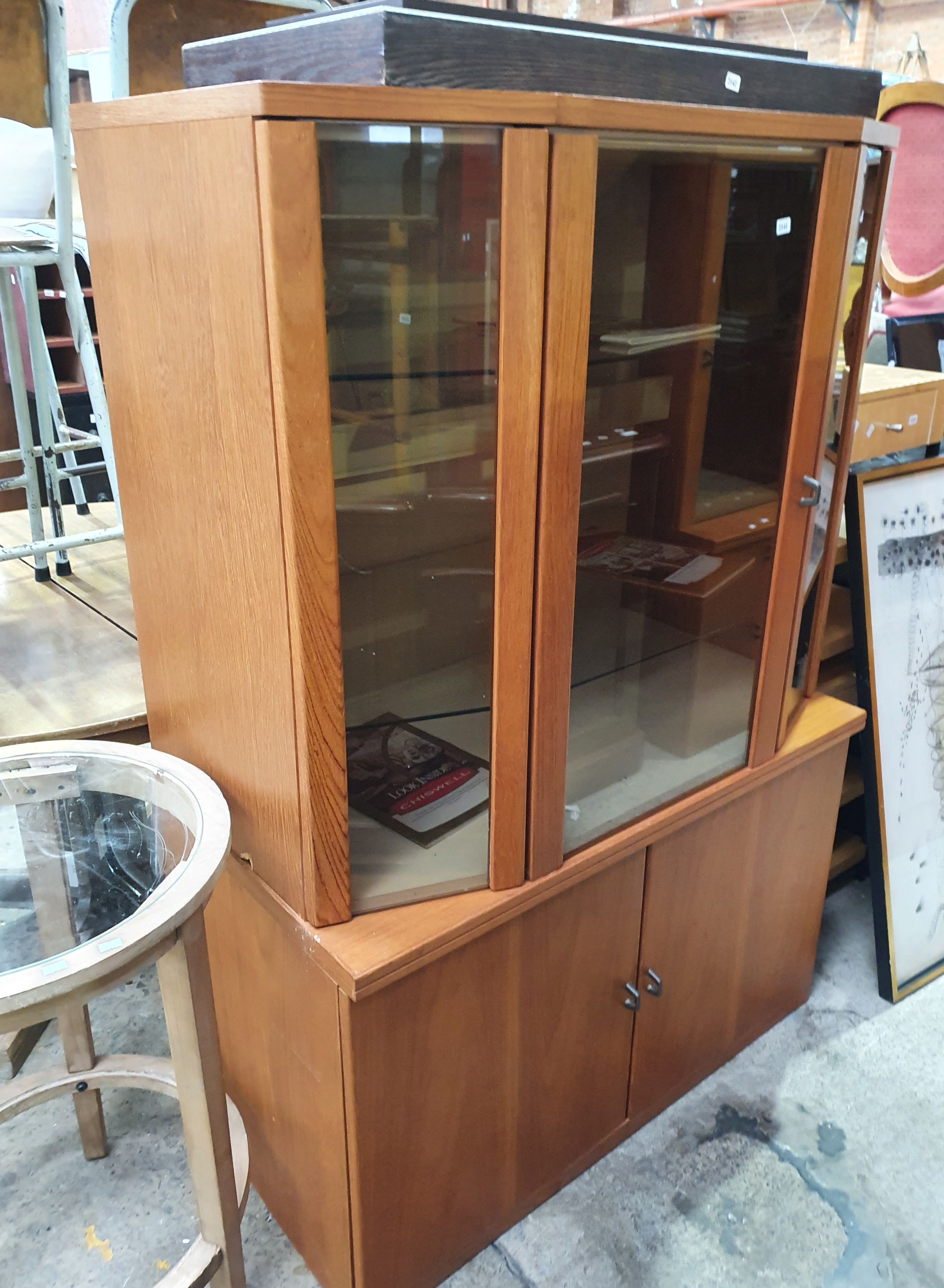 2141 · A CHISWELL TEAK ELEVATED DISPLAY CABINET OF THREE DOORS