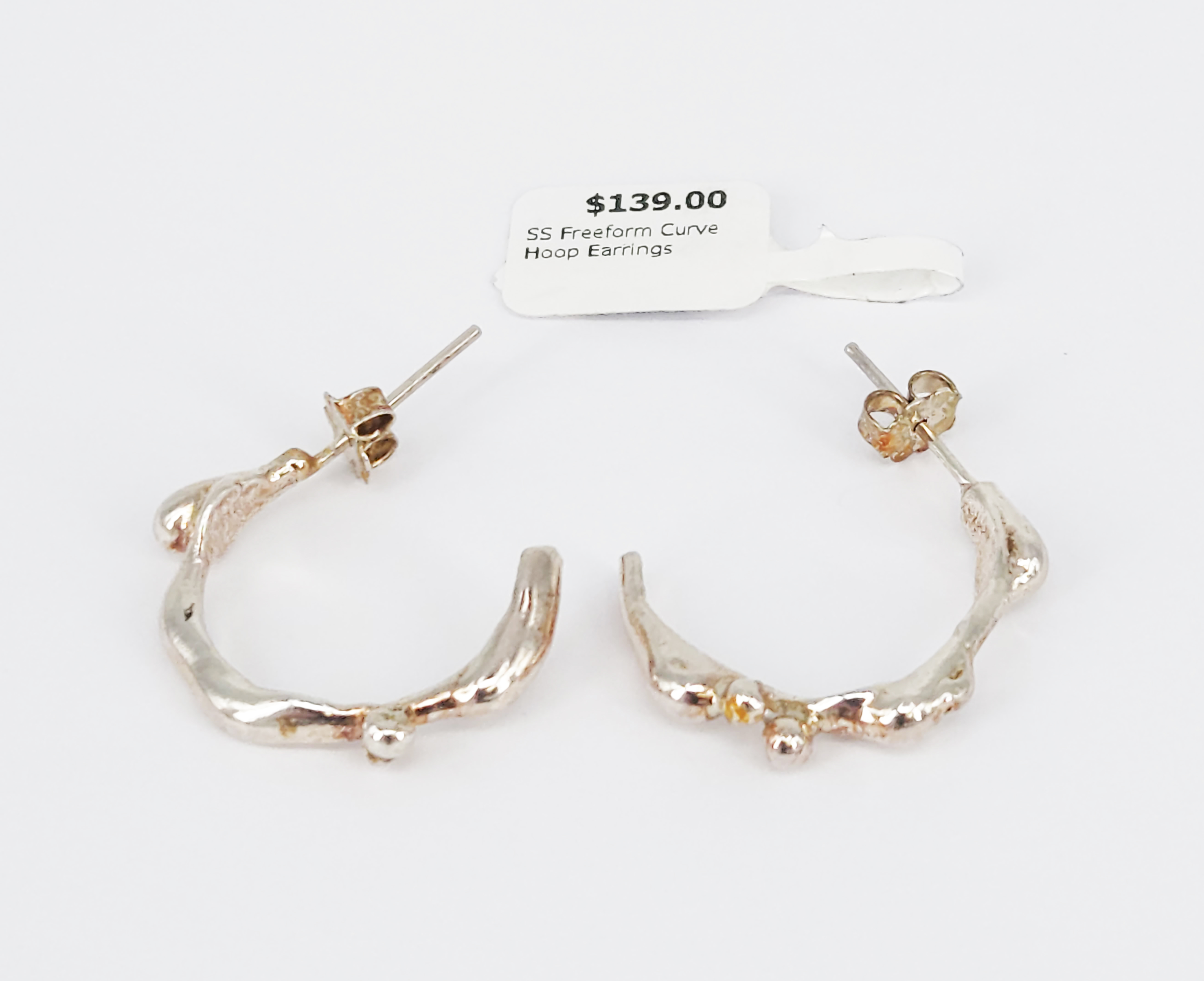 391 · A PAIR OF STERLING SILVER FREE-FORM POURED HALF HOOP EARRINGS