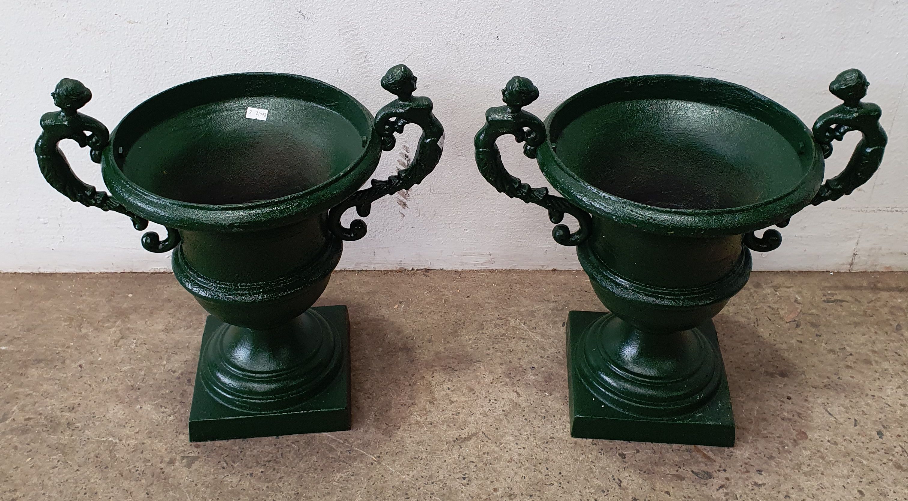 1285 · A PAIR OF GREEN PAINTED CAST IRON URNS