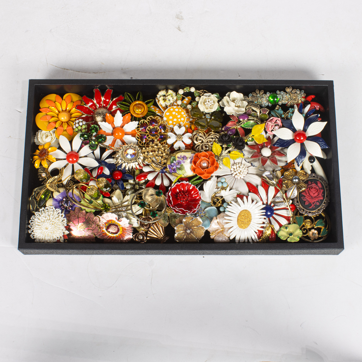 Sixty-three costume jewelry brooches of flowers, comprising Sara