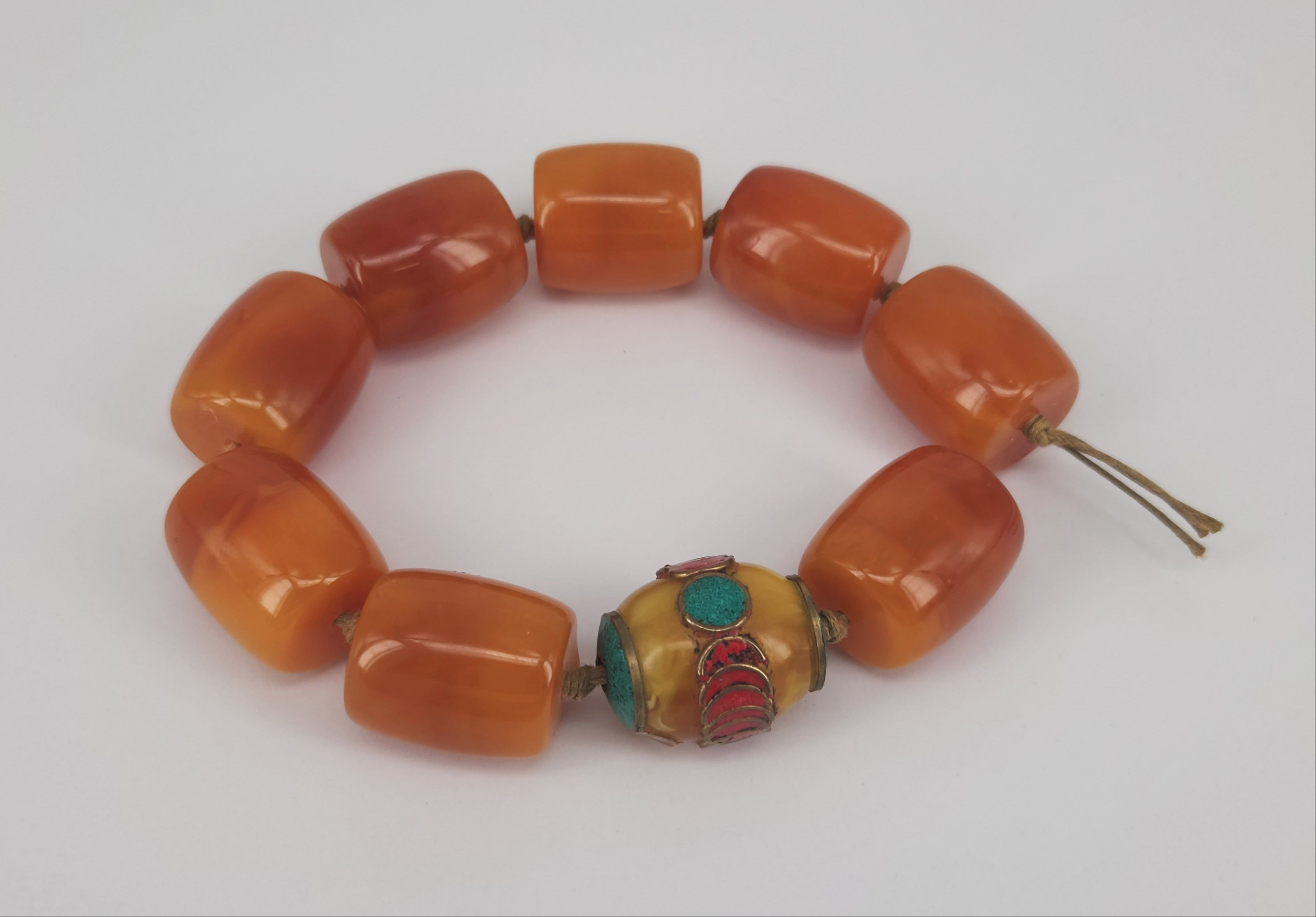 A STRAND OF NINE BUTTERSCOTCH AMBER BEADS