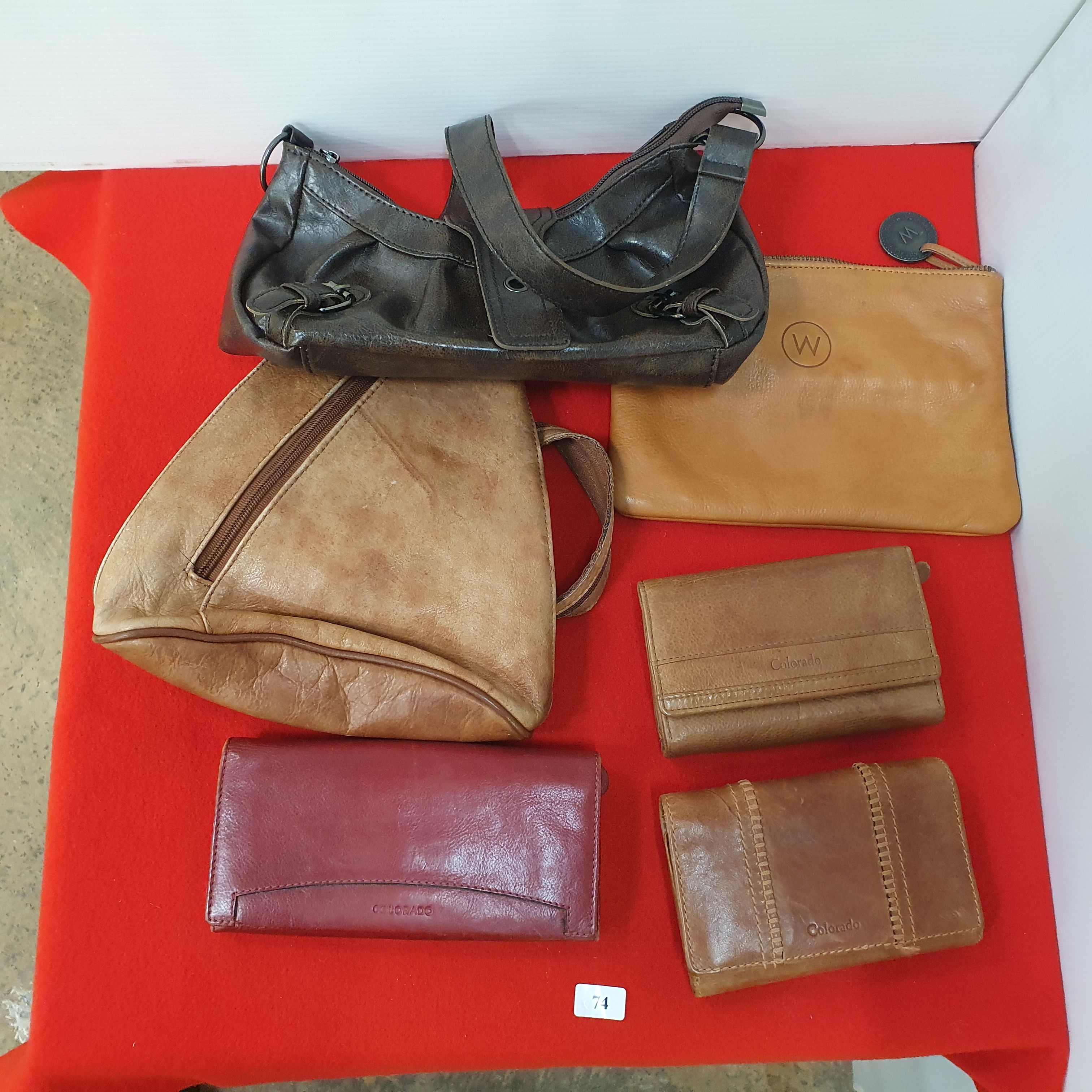 74 · A GROUP OF LEATHER WALLETS AND BAGS