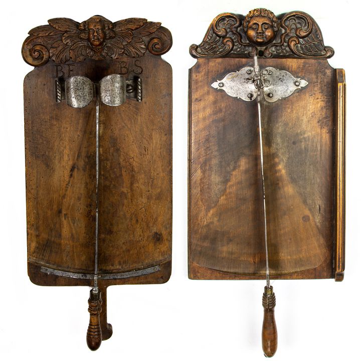 Two French carved walnut cutting boards with knife with amorini crests 18th century