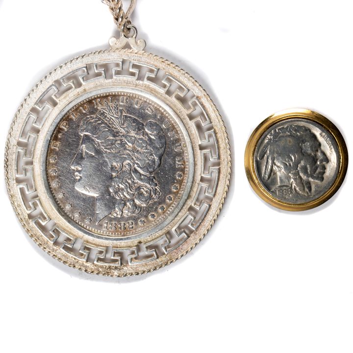 A (lot of 2) coin jewelry items: a 1882 Morgan dollar mounted in a Greek key bezel surround mounted on a silver link necklace; en su...