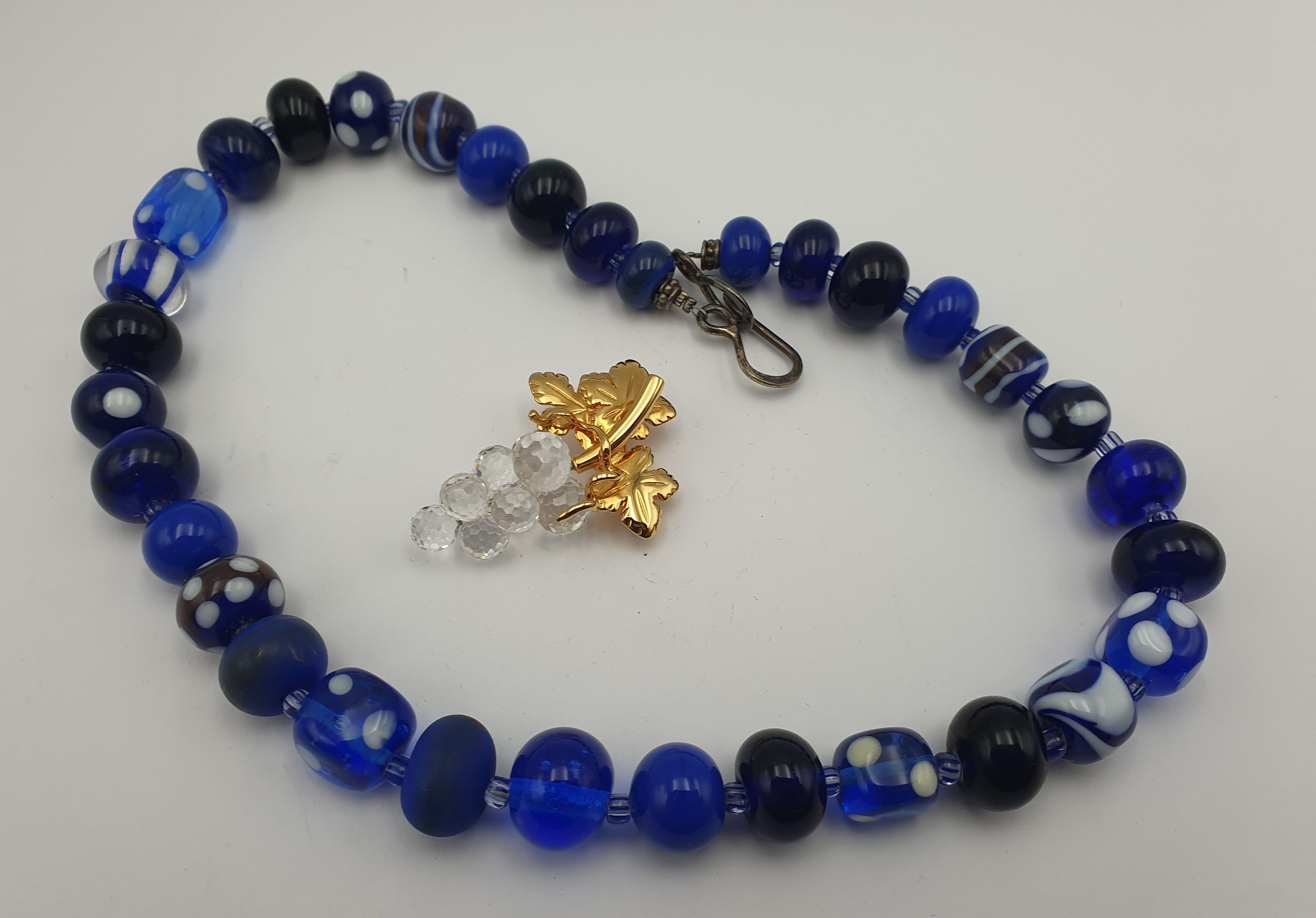 367 · AN AUSTRALIAN GLASS BEAD NECKLACE AND A SWAROVSKI 'GRAPE' BROOCH