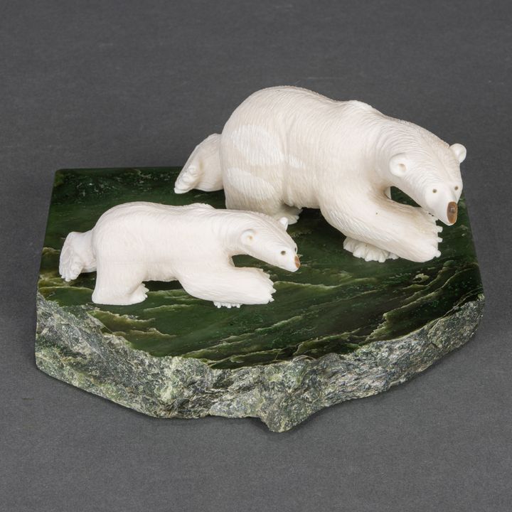 A Dennis James Jr. (Ungaluk) Inuit walrus tusk and jade stone group of two polar bears on rock, signed on paws