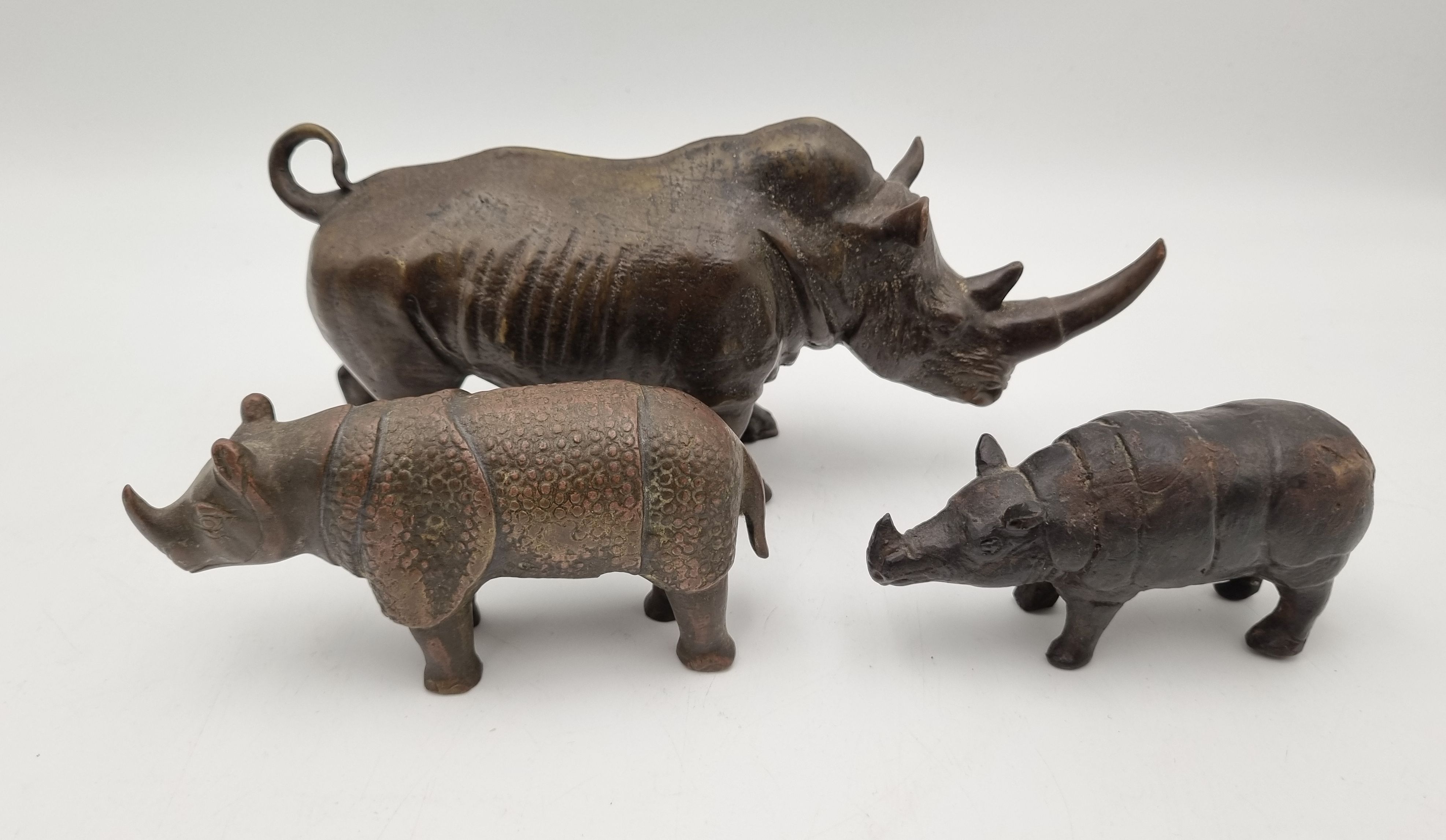555 · THREE CAST METAL FIGURES OF RHINOS