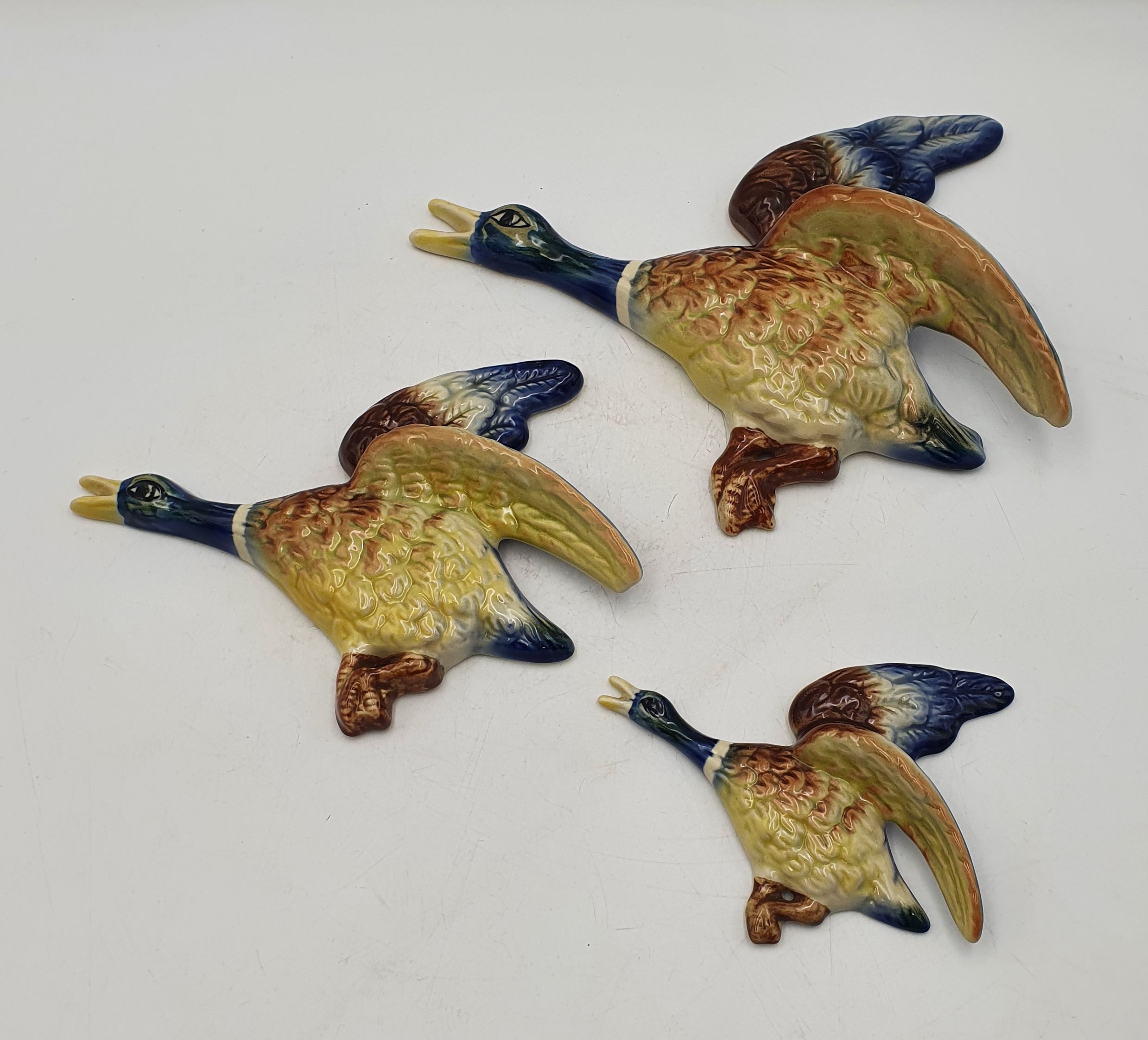 590 · A SET OF THREE MCP POTTERY GRADUATING BIRDS IN FLIGHT