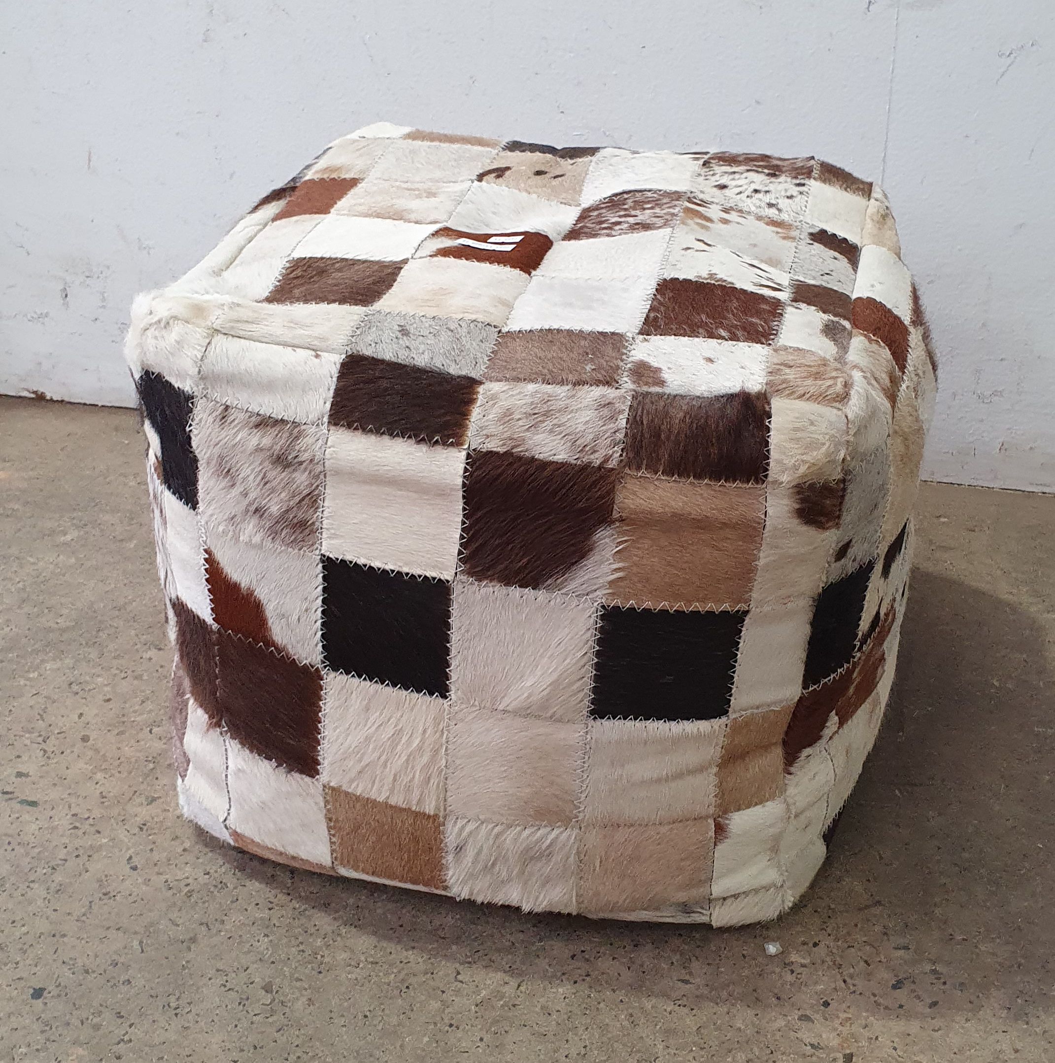 A PATCHWORK COW HIDE STOOL