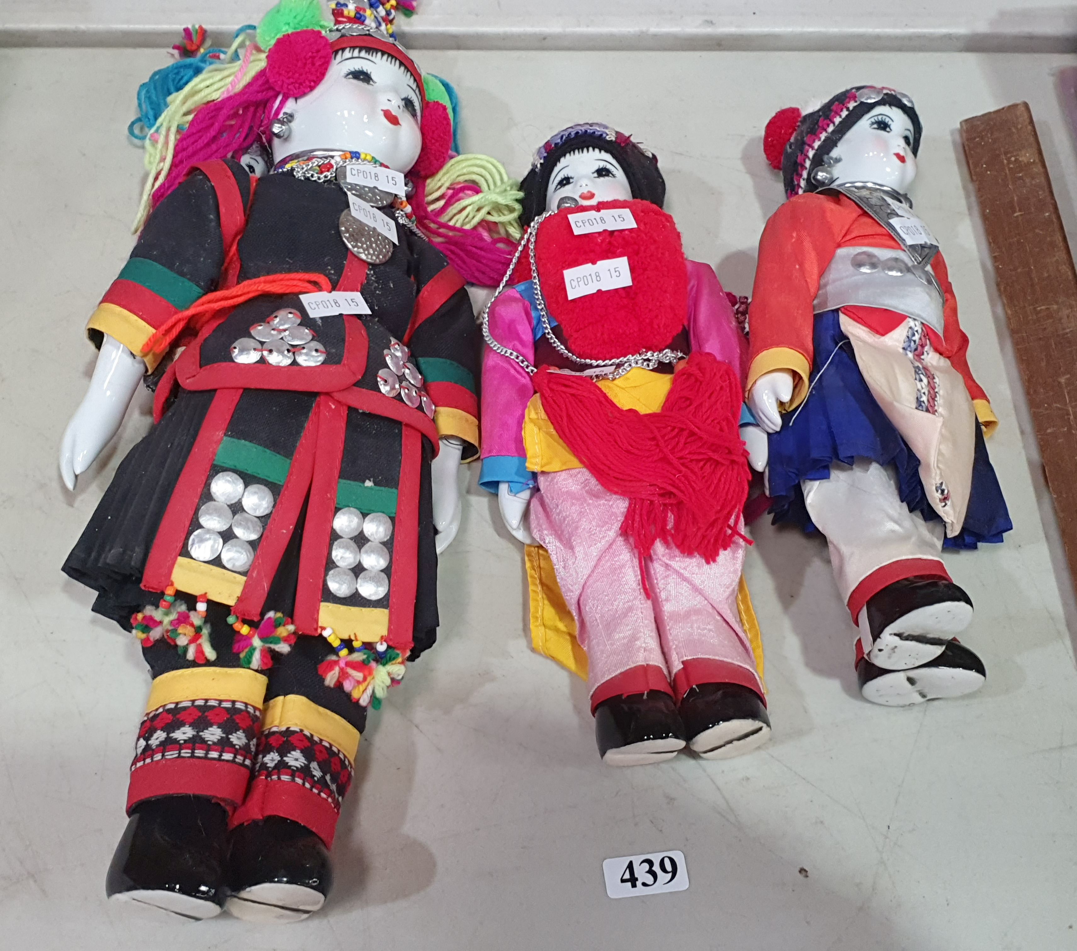 439 · THREE PORCELAIN DOLLS IN ASIAN FOLK COSTUMES