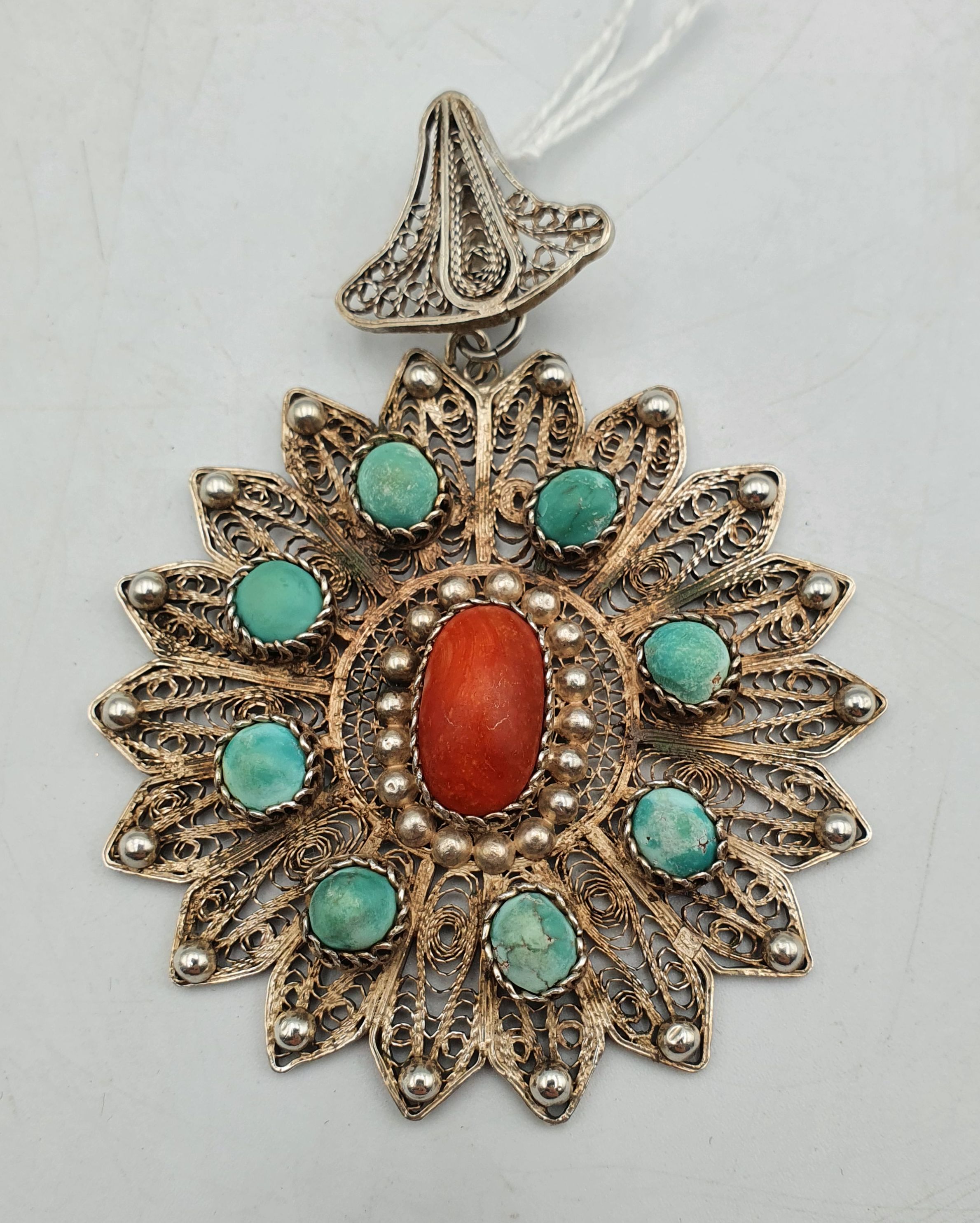 258 · A LARGE SILVER FILIGREE PENDANT WITH CORAL AND TURQUOISE INCLUSIONS
