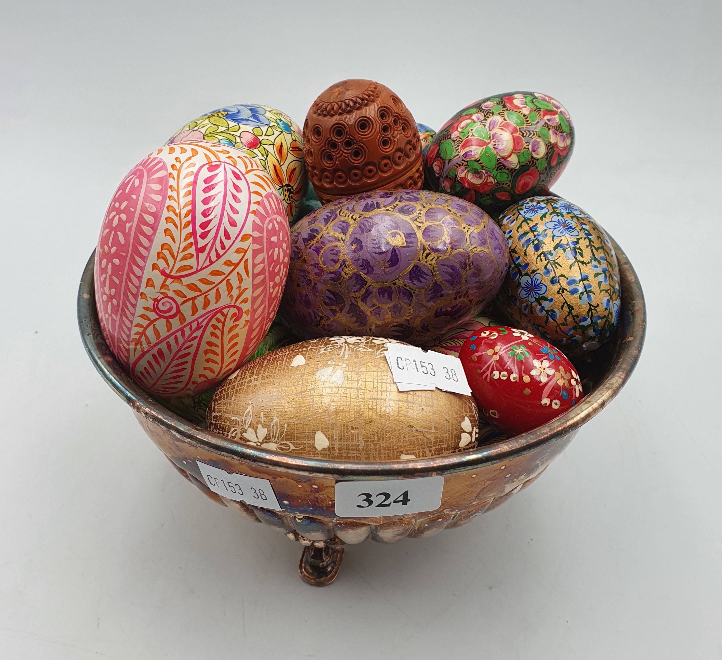 324 · A SILVERPLATED BOWL RAISED ON THREE FEET FILLED WITH COLOURFUL EGGS