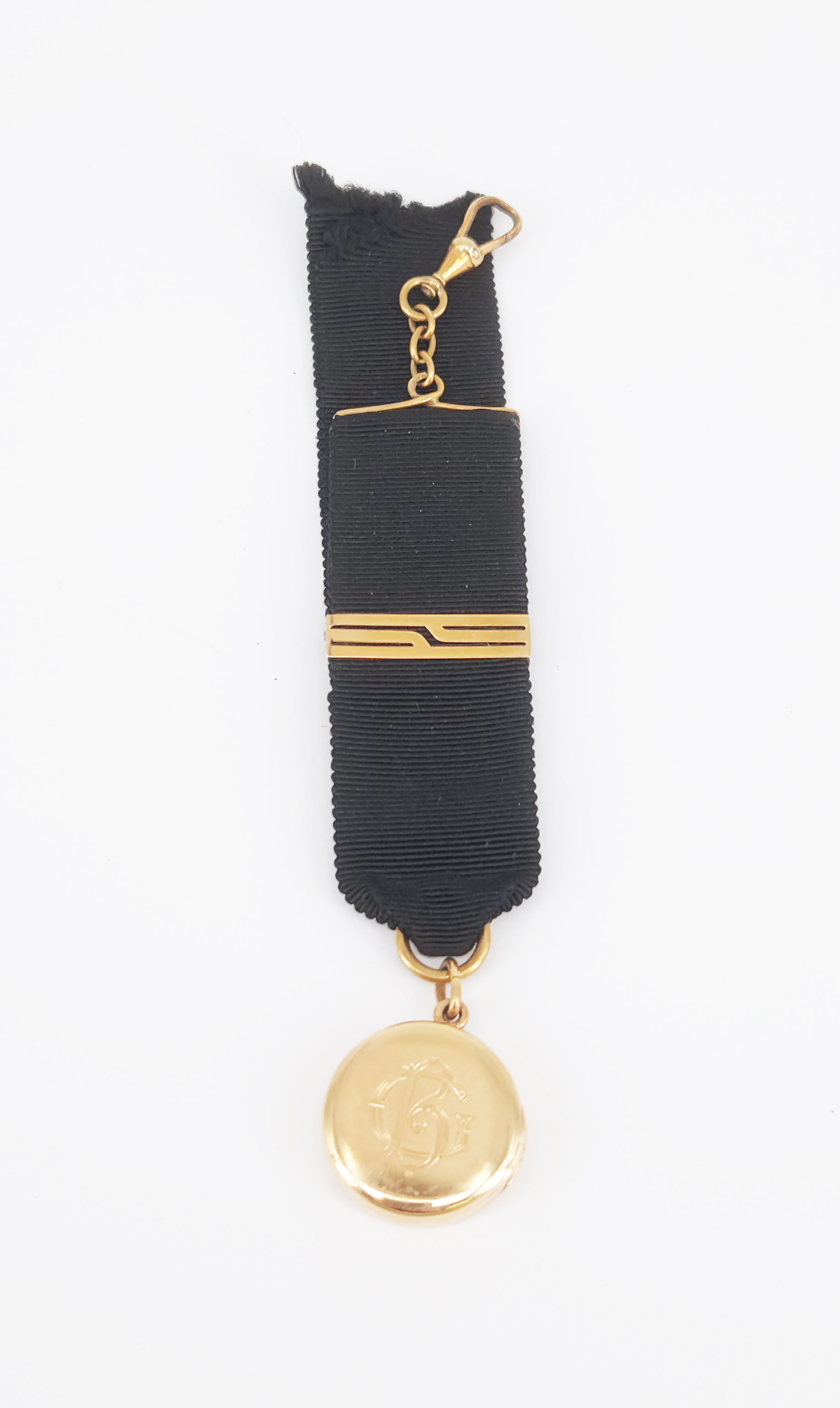 A Rose Gold Locket On Black Ribbon