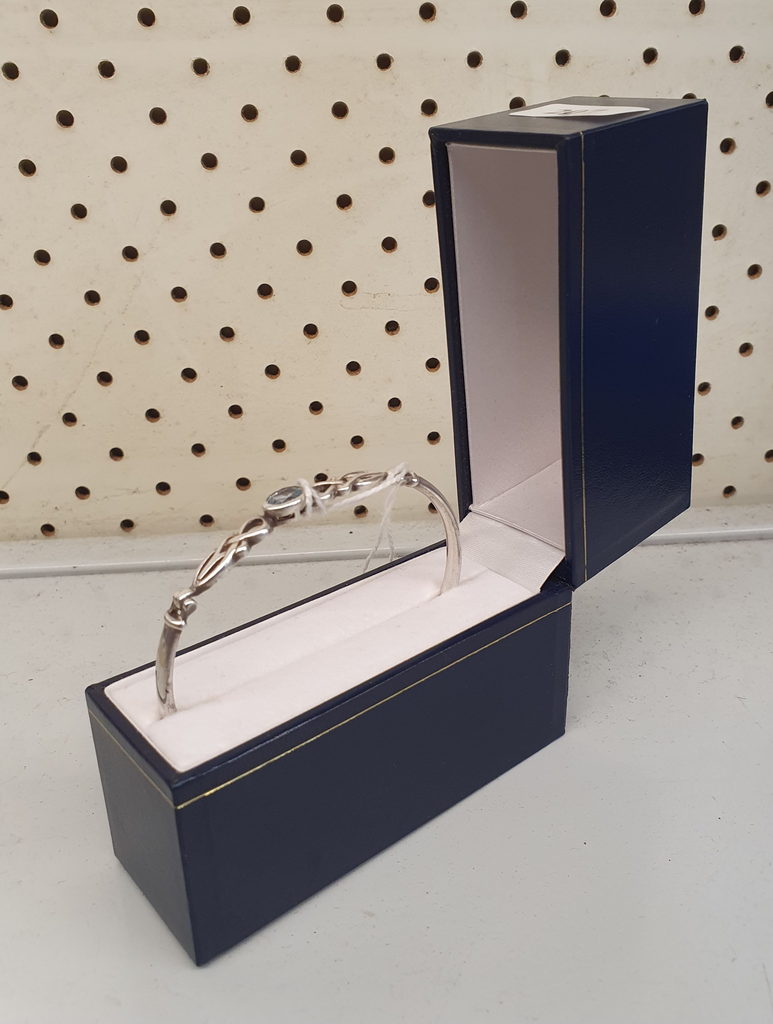 207 · A LADIES STERLING SILVER AND BLUE TOPAZ BANGLE