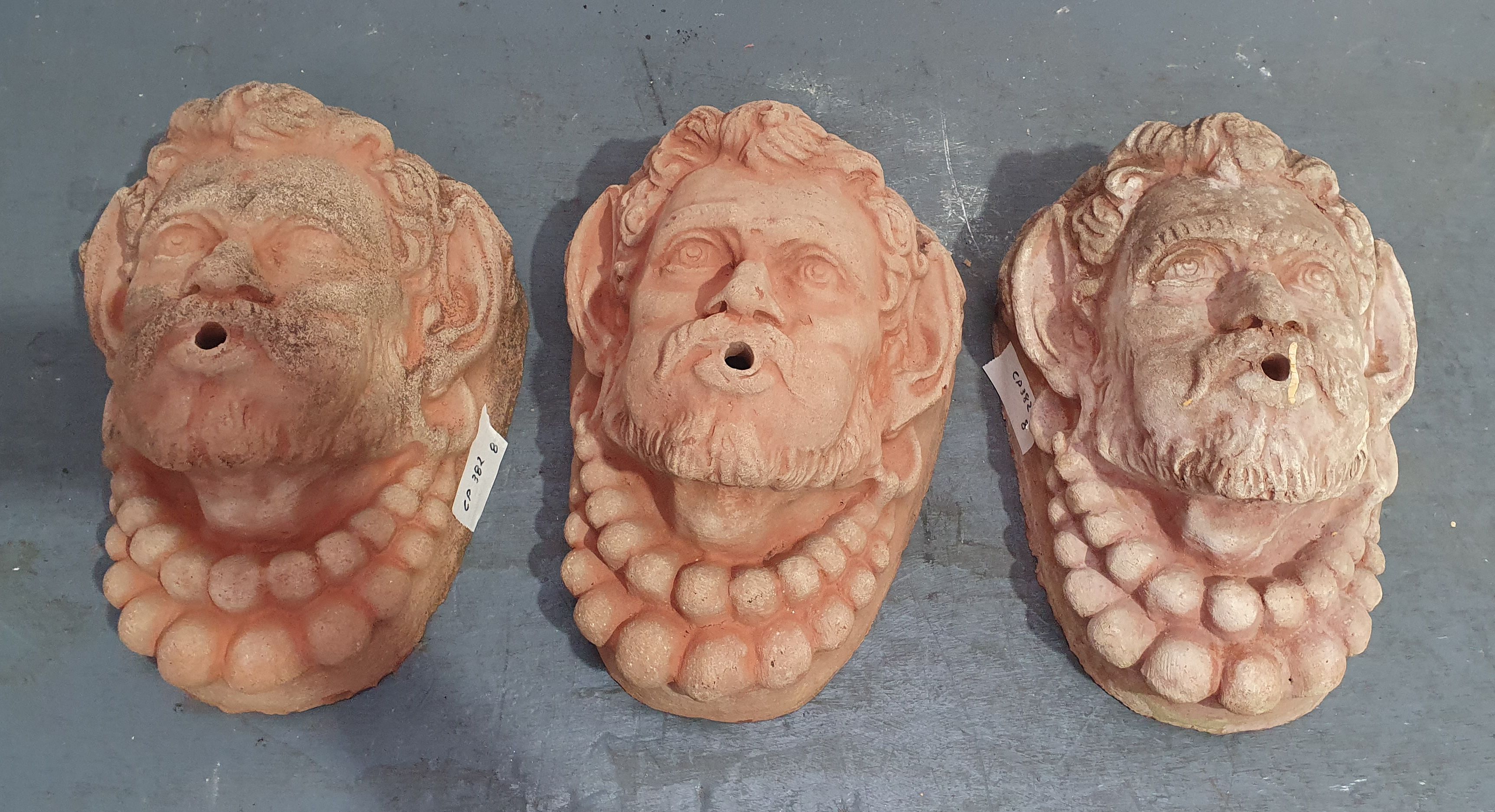 1069 · THREE TERRACOTTA FOUNTAIN MASKS