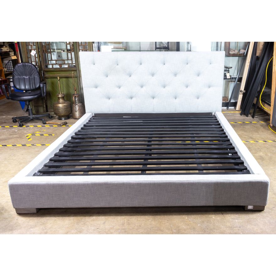 A contemporary Restoration Hardware grey tufted bed