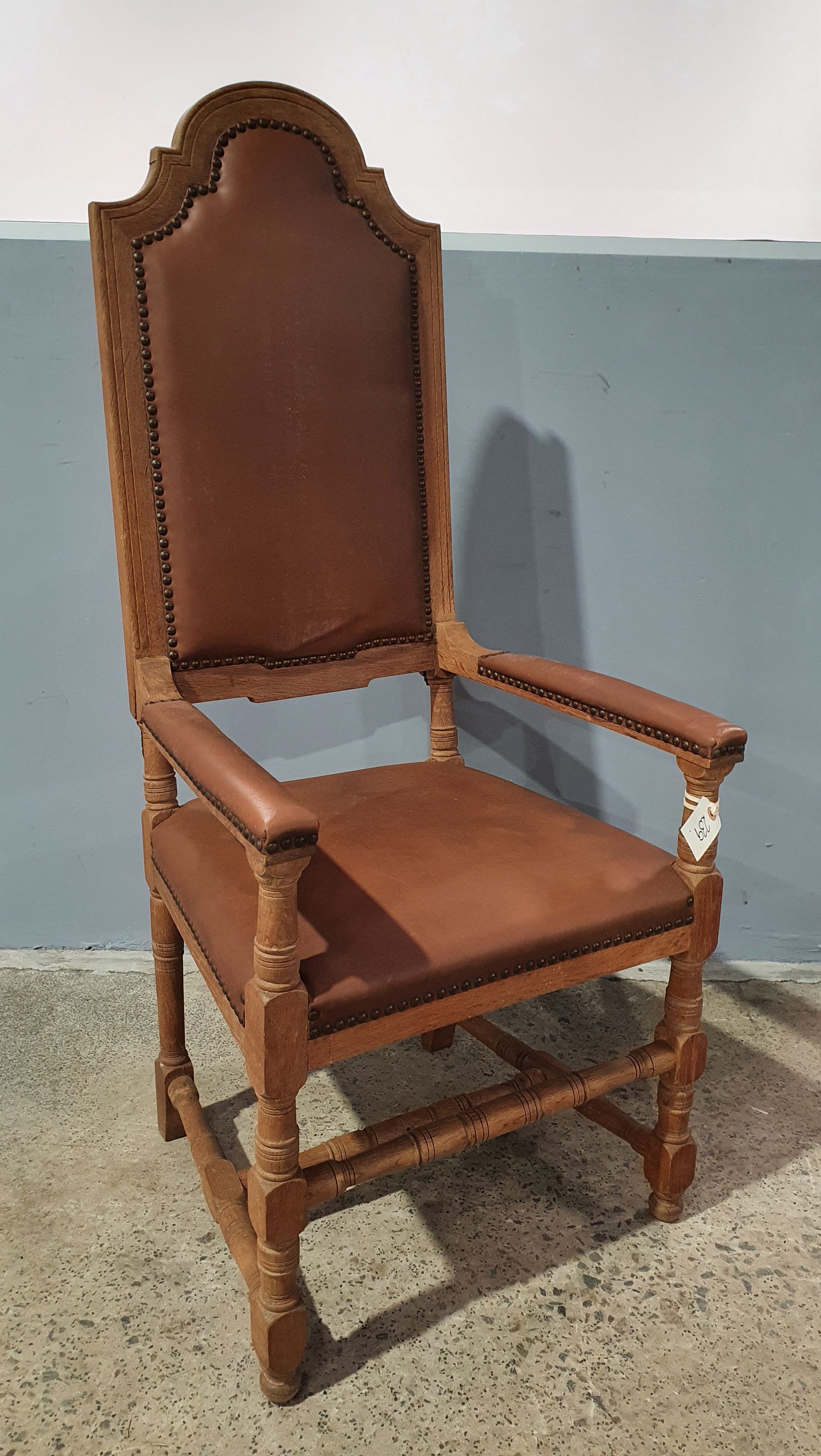 AN UPHOLSTERED LEATHER OAK CHAIR