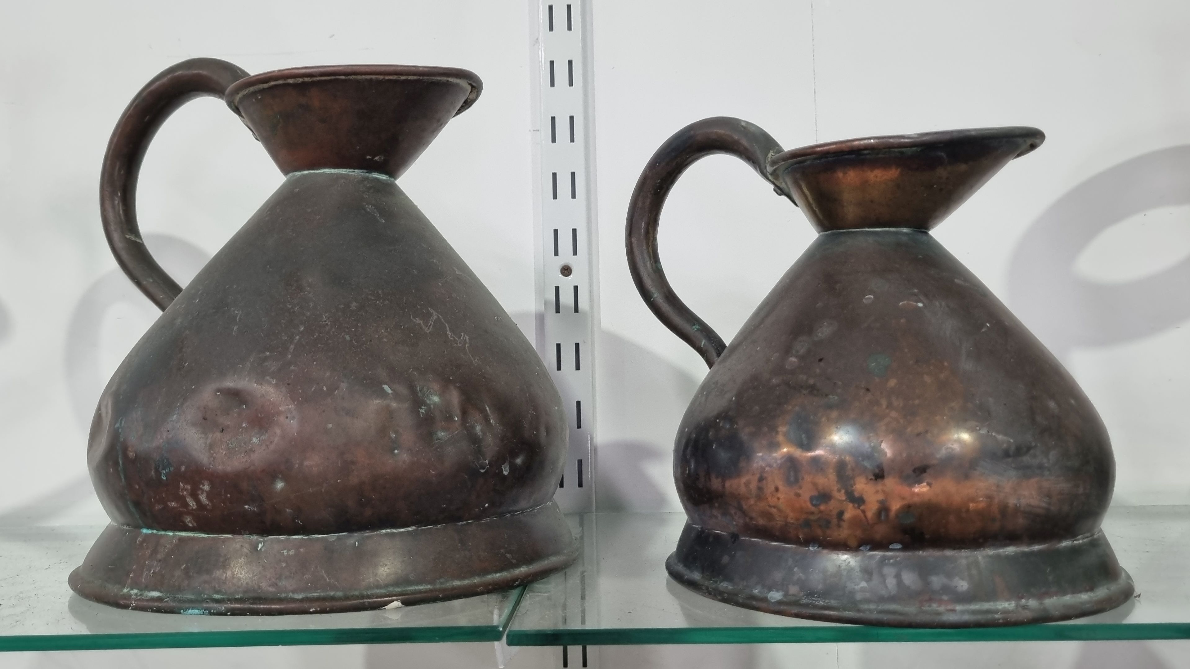 A PAIR OF VICTORIAN COPPER MEASURING JUGS
