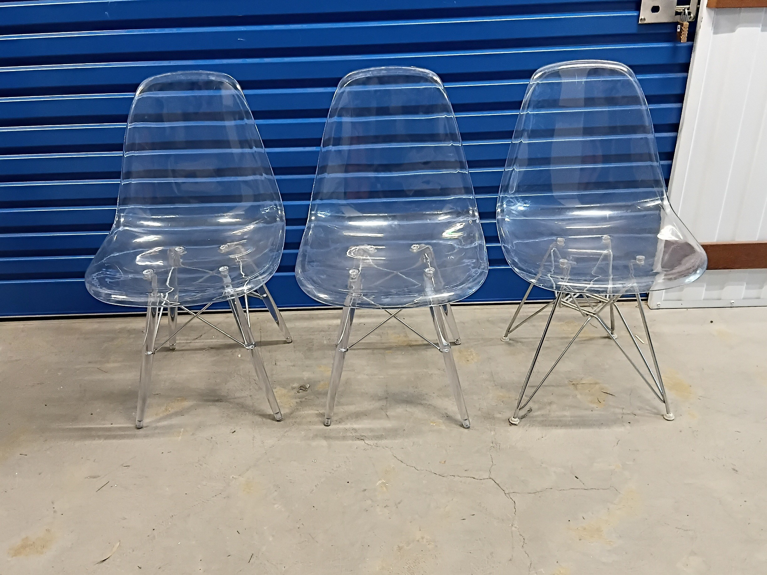 A SET OF THREE EAMES STYLE PERSPEX CHAIRS
