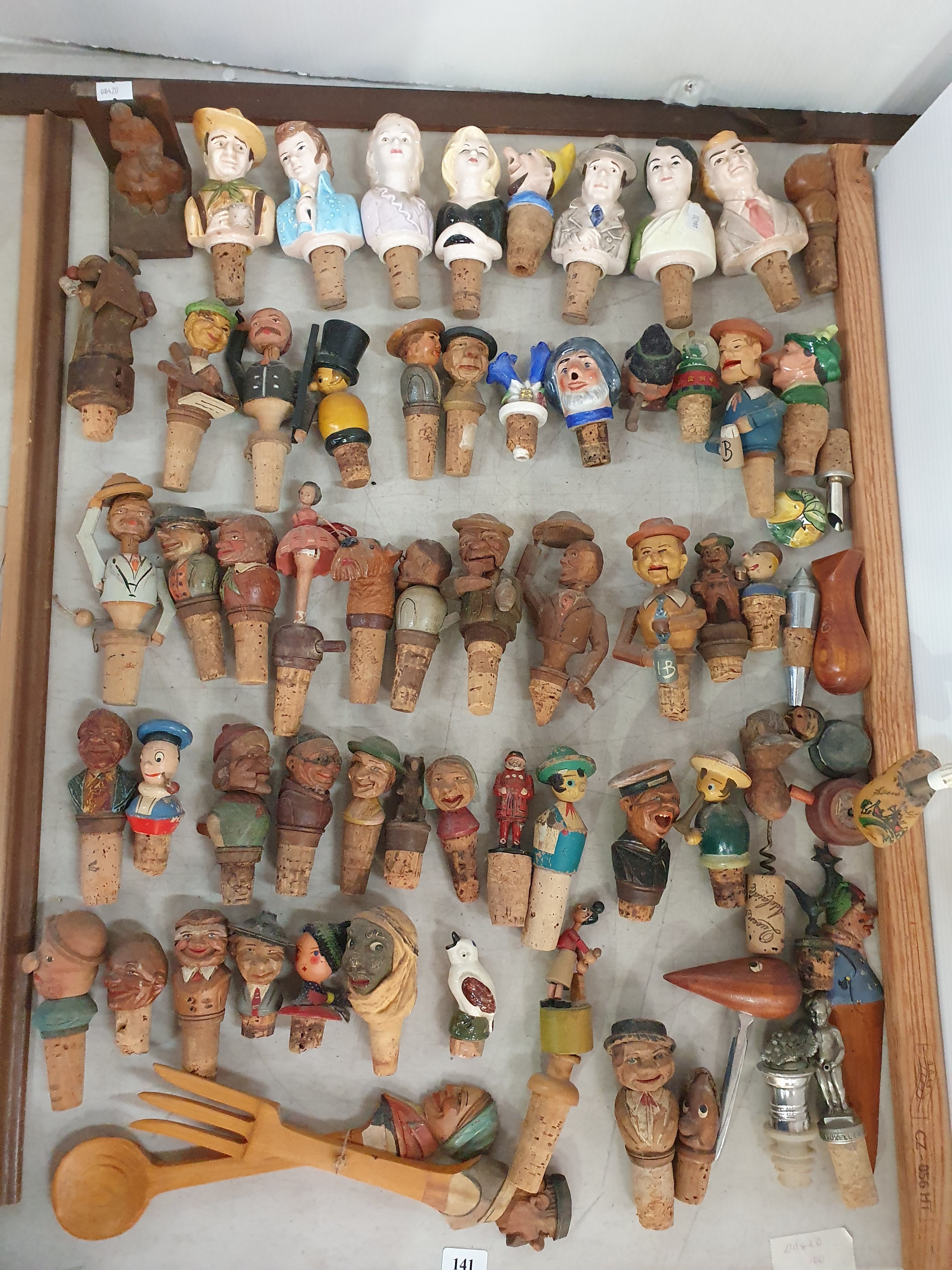 141 · A COLLECTION OF FIGURAL BOTTLE STOPPERS WITH CORK BASES