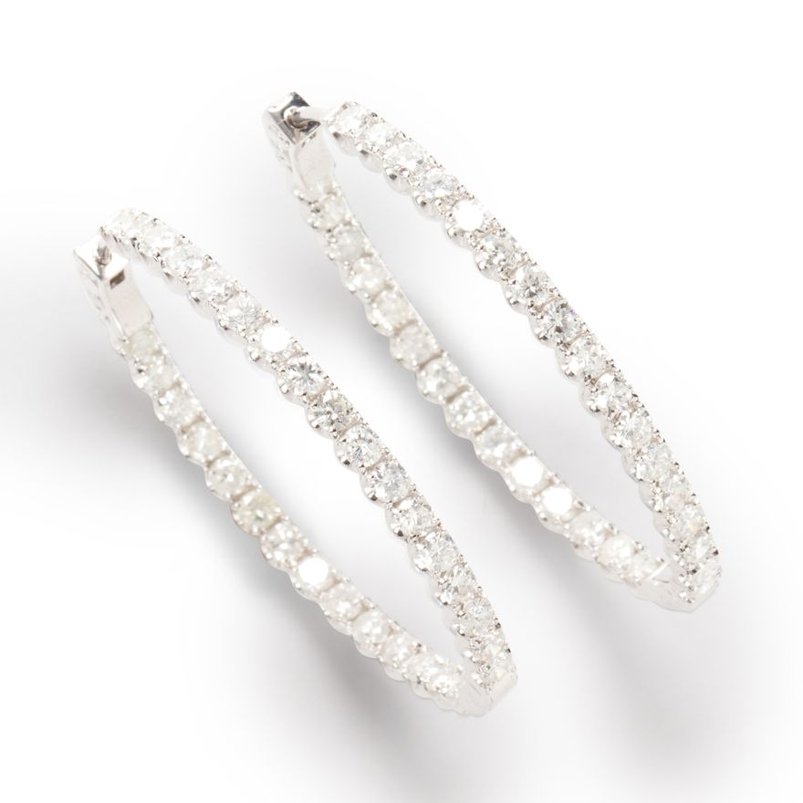 A pair of diamond and eighteen karat white gold hoop earrings