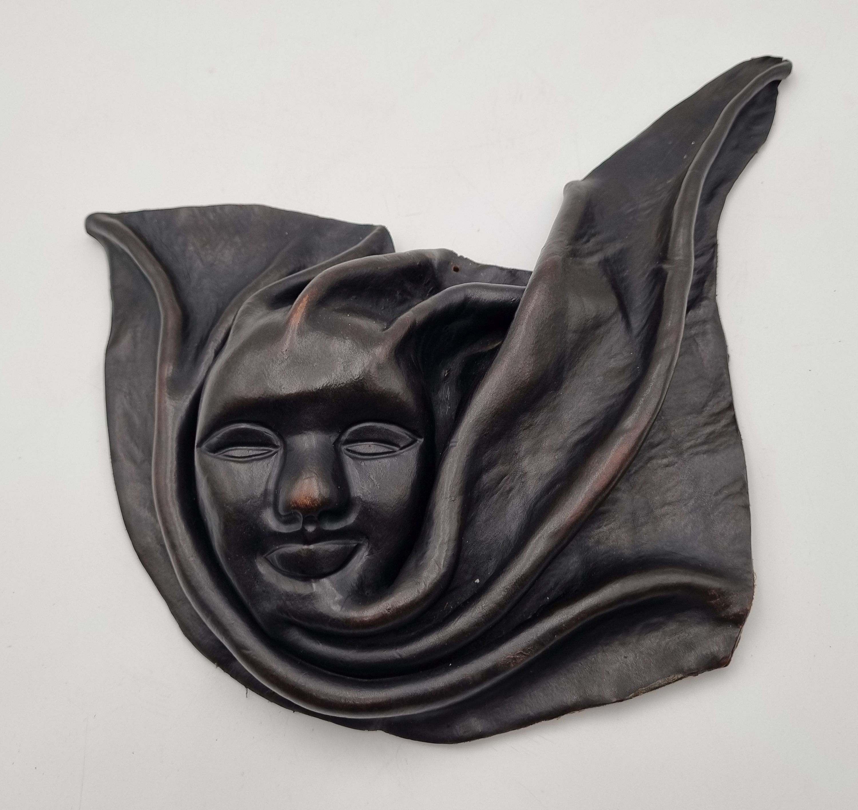 615 · A SMALL VINTAGE HAITIAN HAND SCULPTED LEATHER MASK