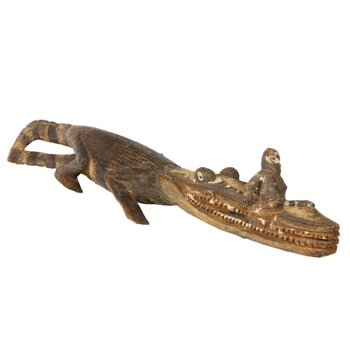 An Asmat polychrome wood carving of crocodile with a praying figure of an ancestor