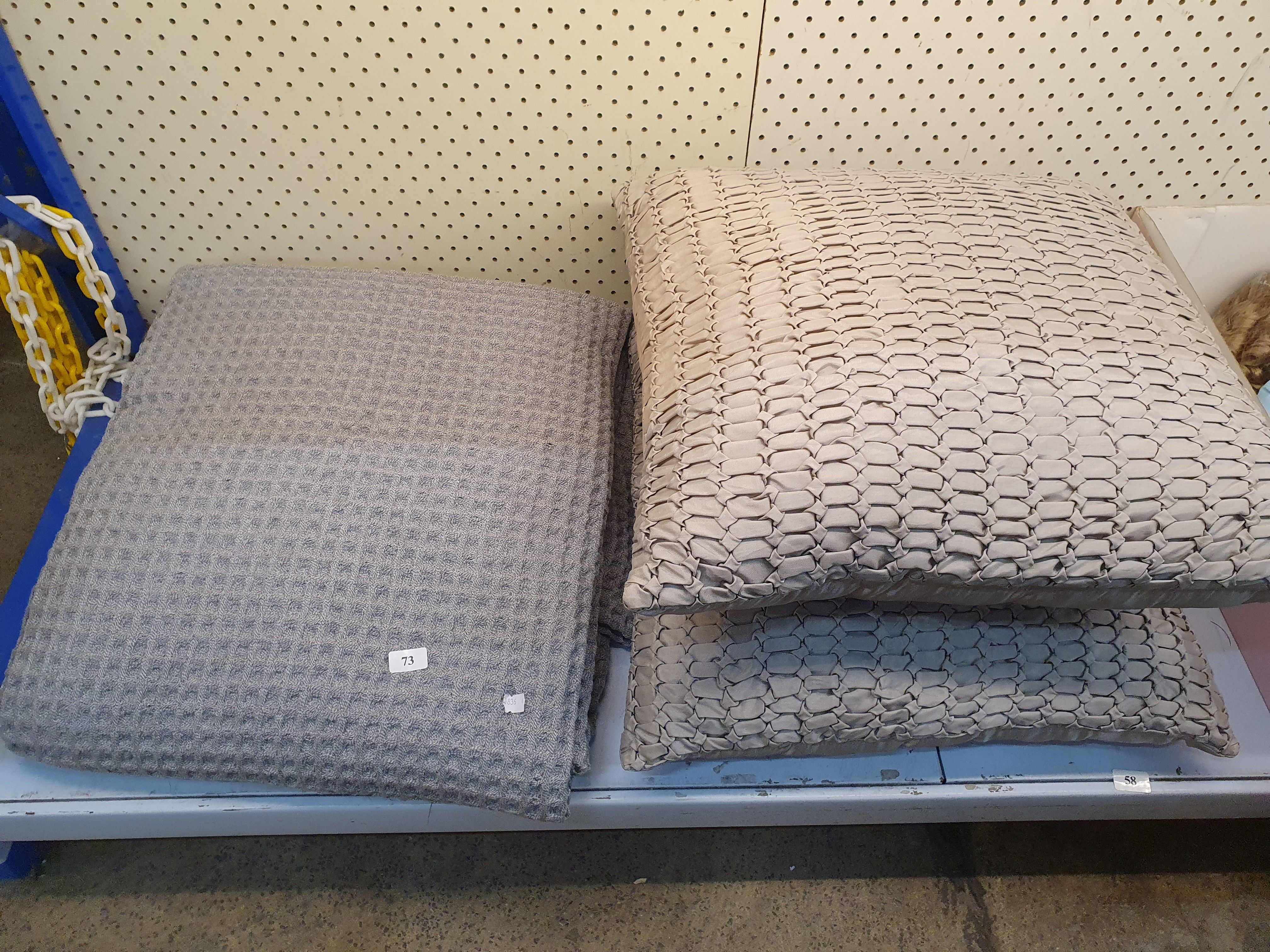 73 · TWO GREY CUSHIONS AND A THROW RUG